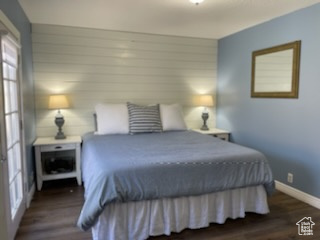 Bedroom with dark hardwood / wood-style floors