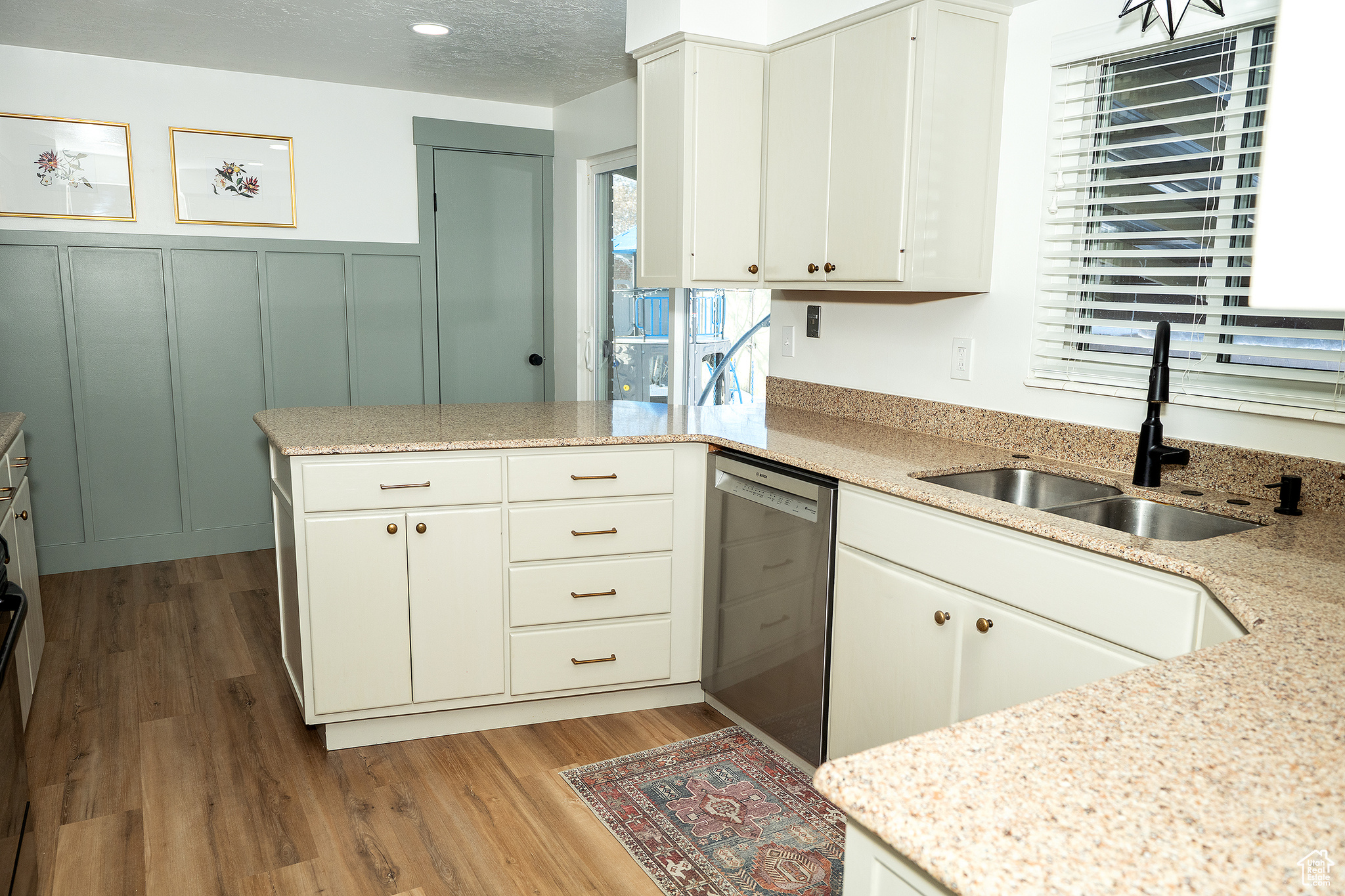 Kitchen with sink, white cabinets, stainless steel dishwasher, light hardwood / wood-style floors, and kitchen peninsula