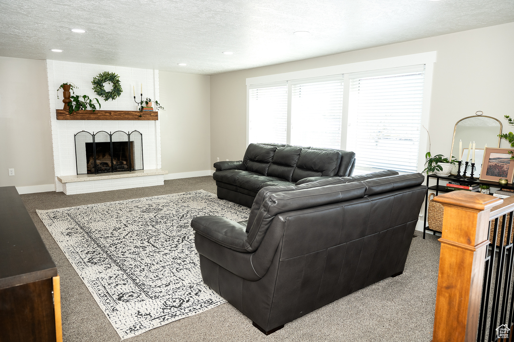 Living room with carpet flooring, a textured ceiling, and a fireplace