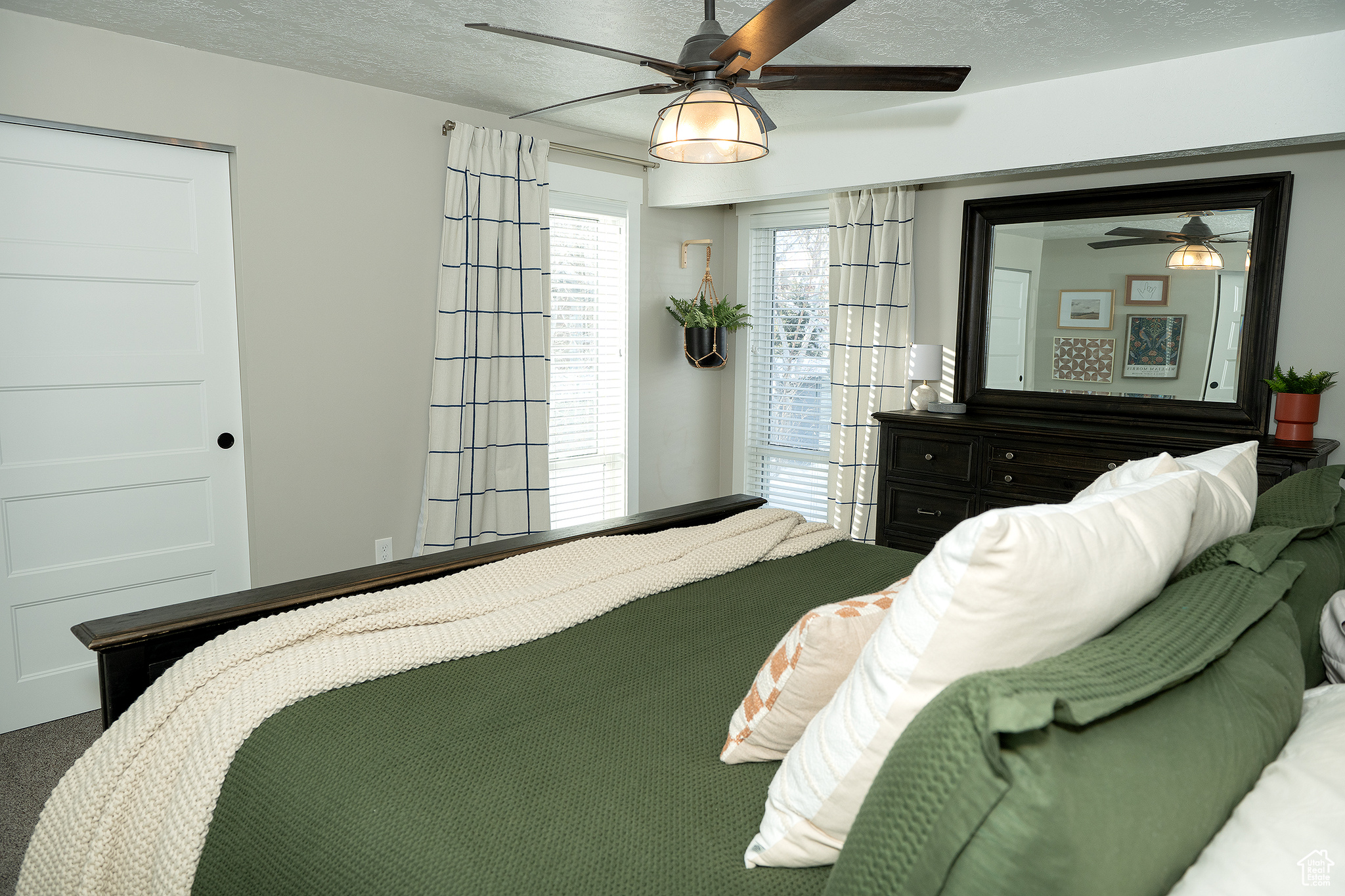 Bedroom with ceiling fan and a textured ceiling