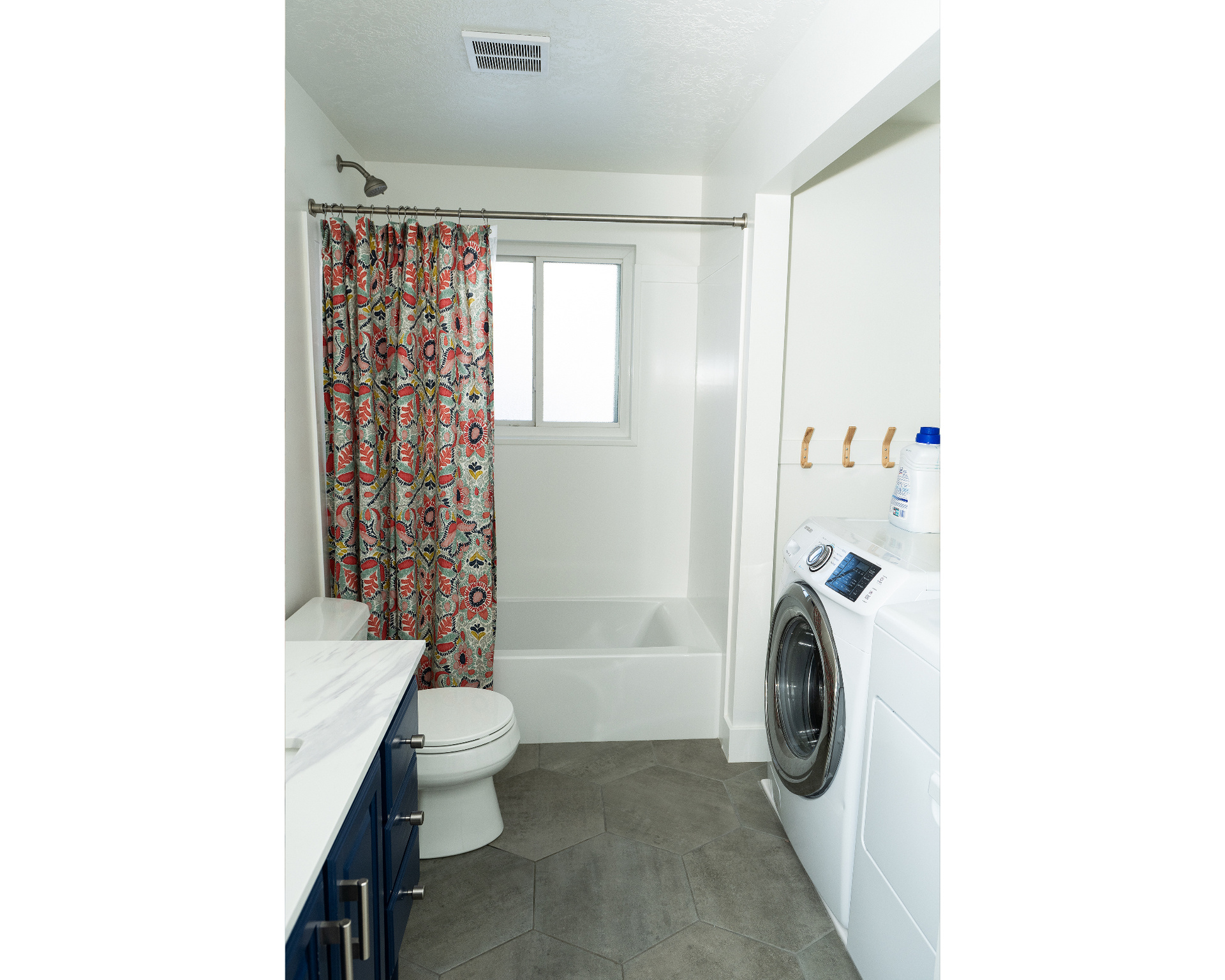 Bathroom featuring visible vents, toilet, shower / bath combo with shower curtain, washing machine and dryer, and a textured ceiling