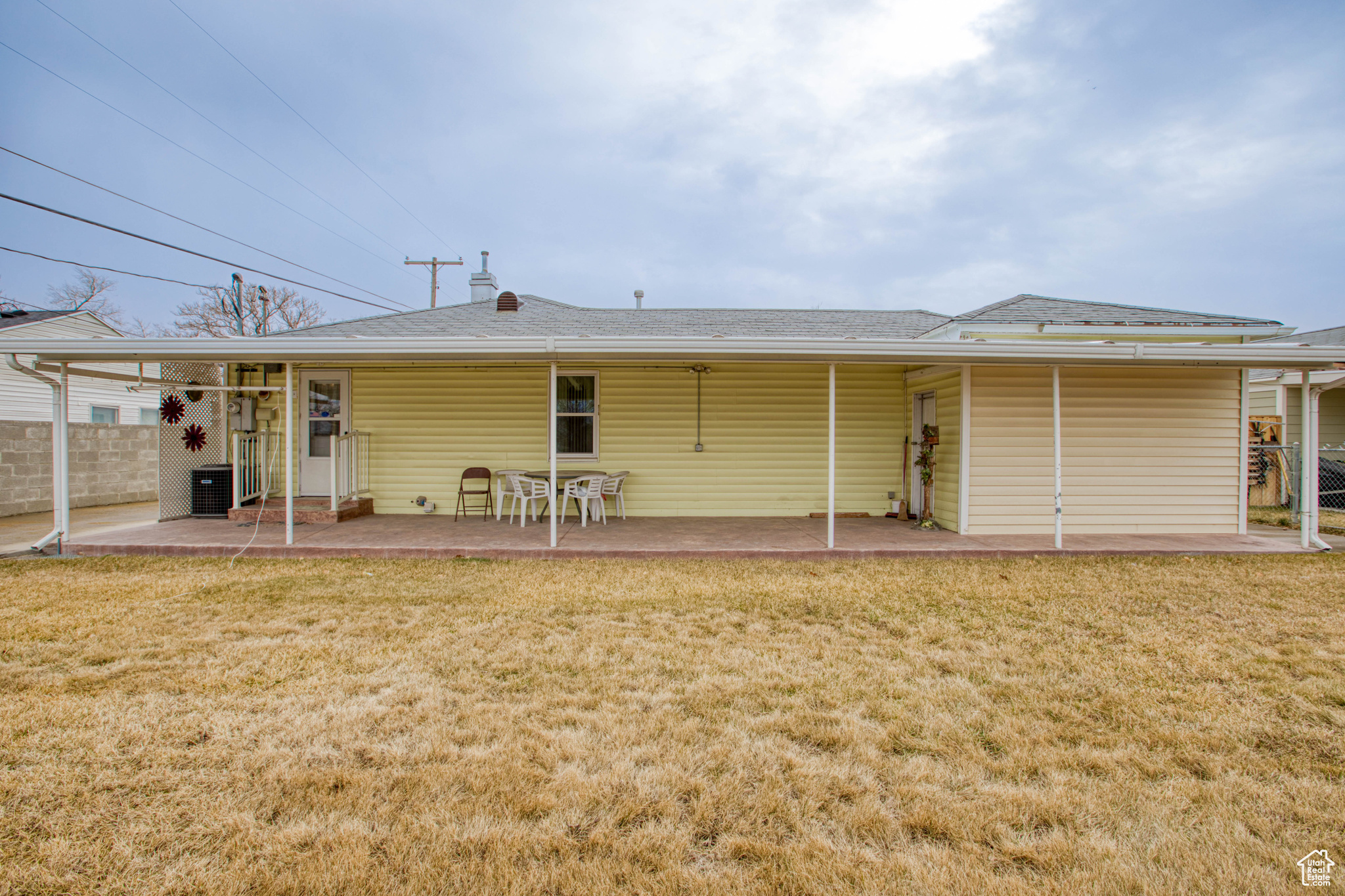 Rear view of property featuring a patio, a yard, and central AC unit