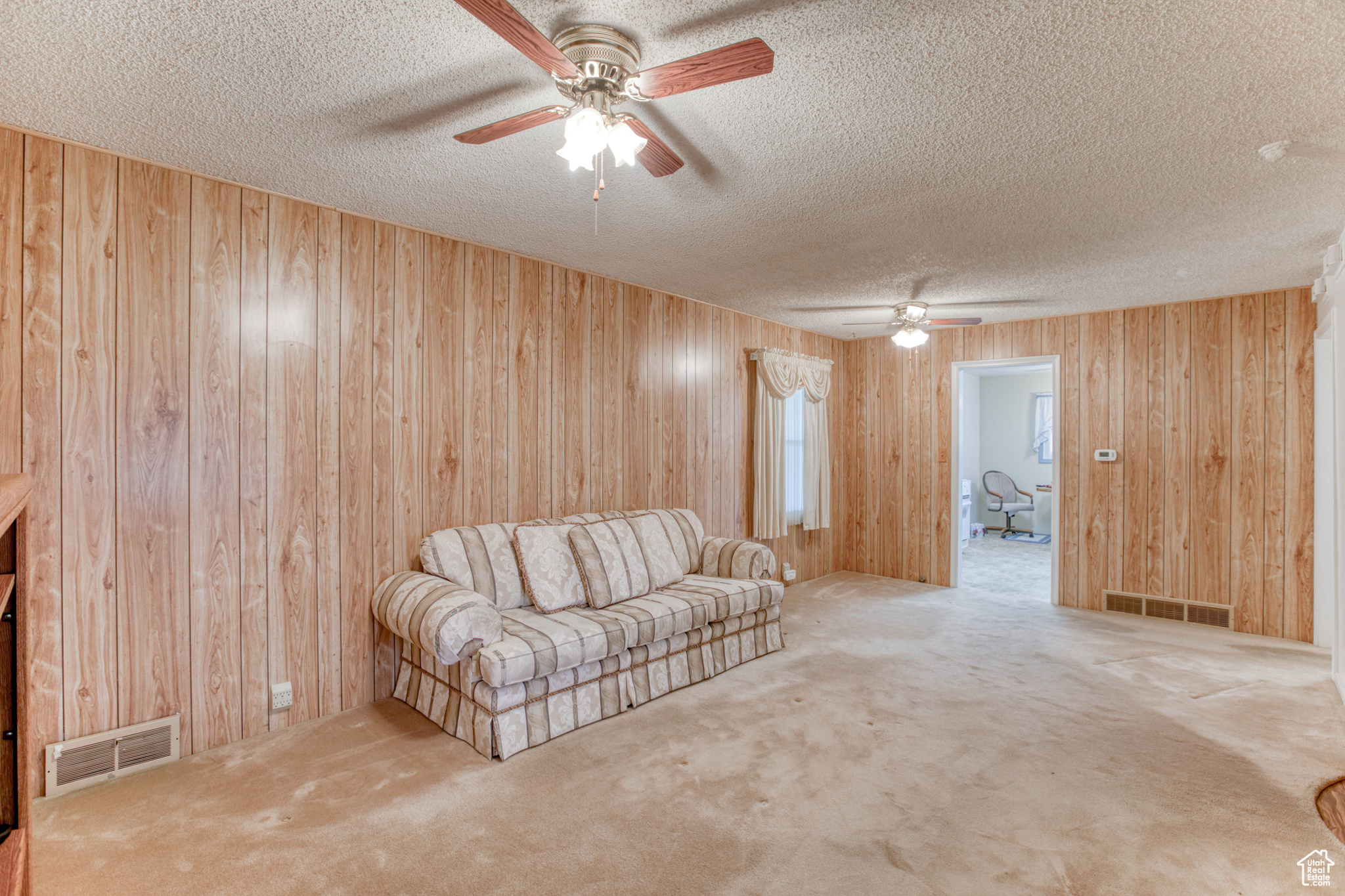 Unfurnished living room with a textured ceiling and wood walls