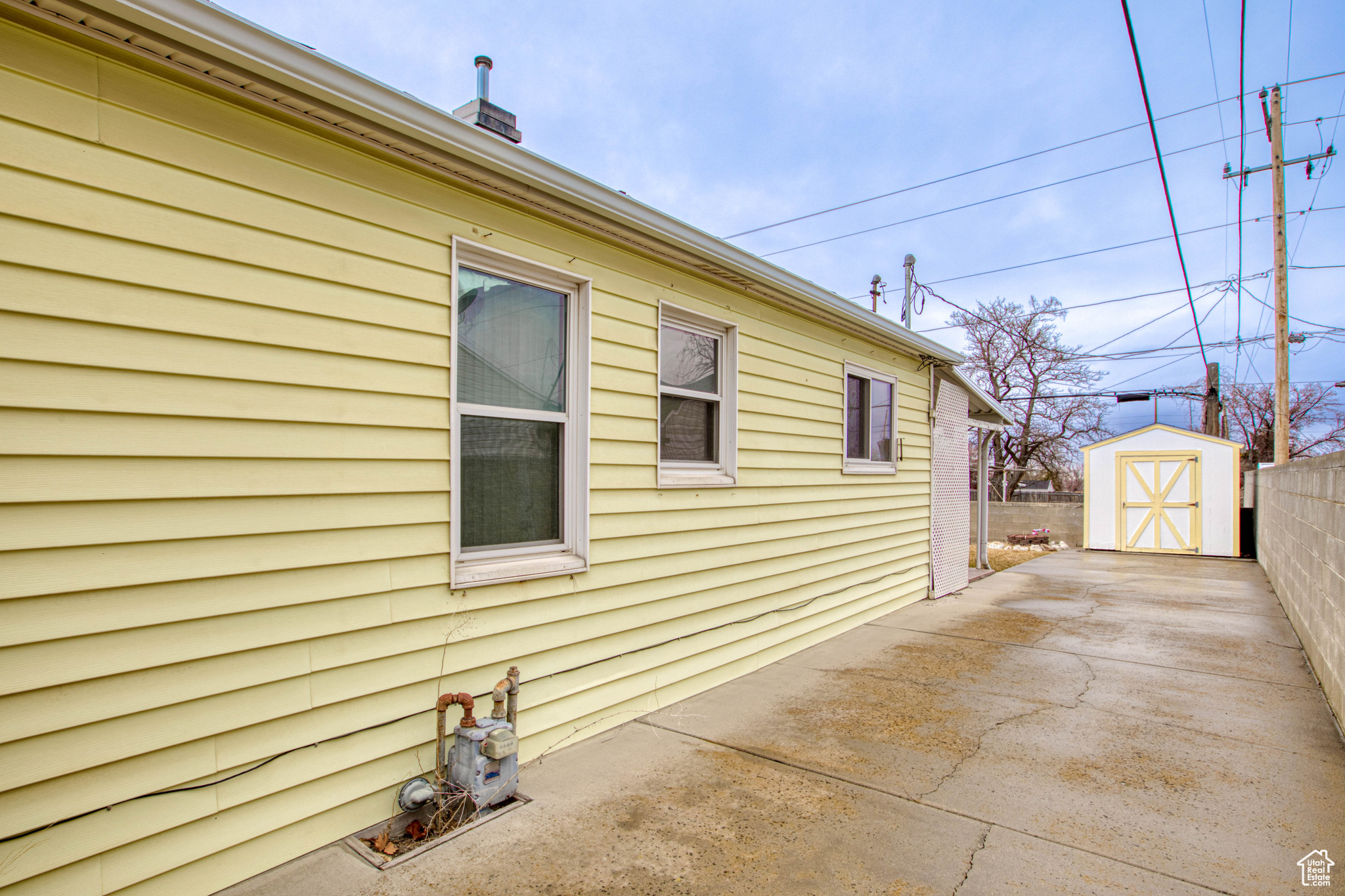 View of home's exterior featuring a storage shed and a patio area