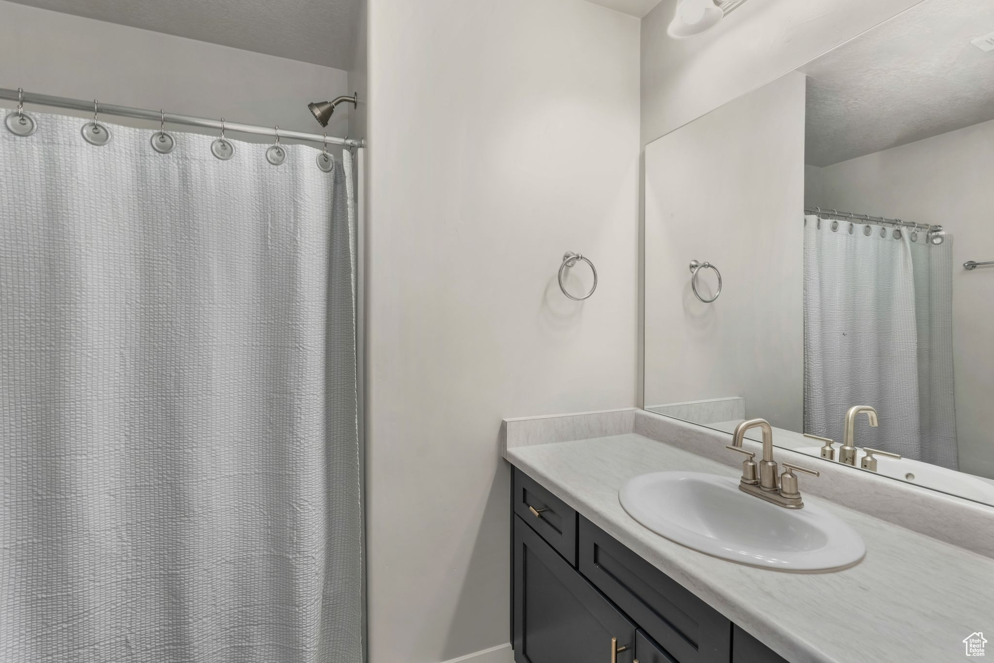 Bathroom with vanity and a shower with shower curtain