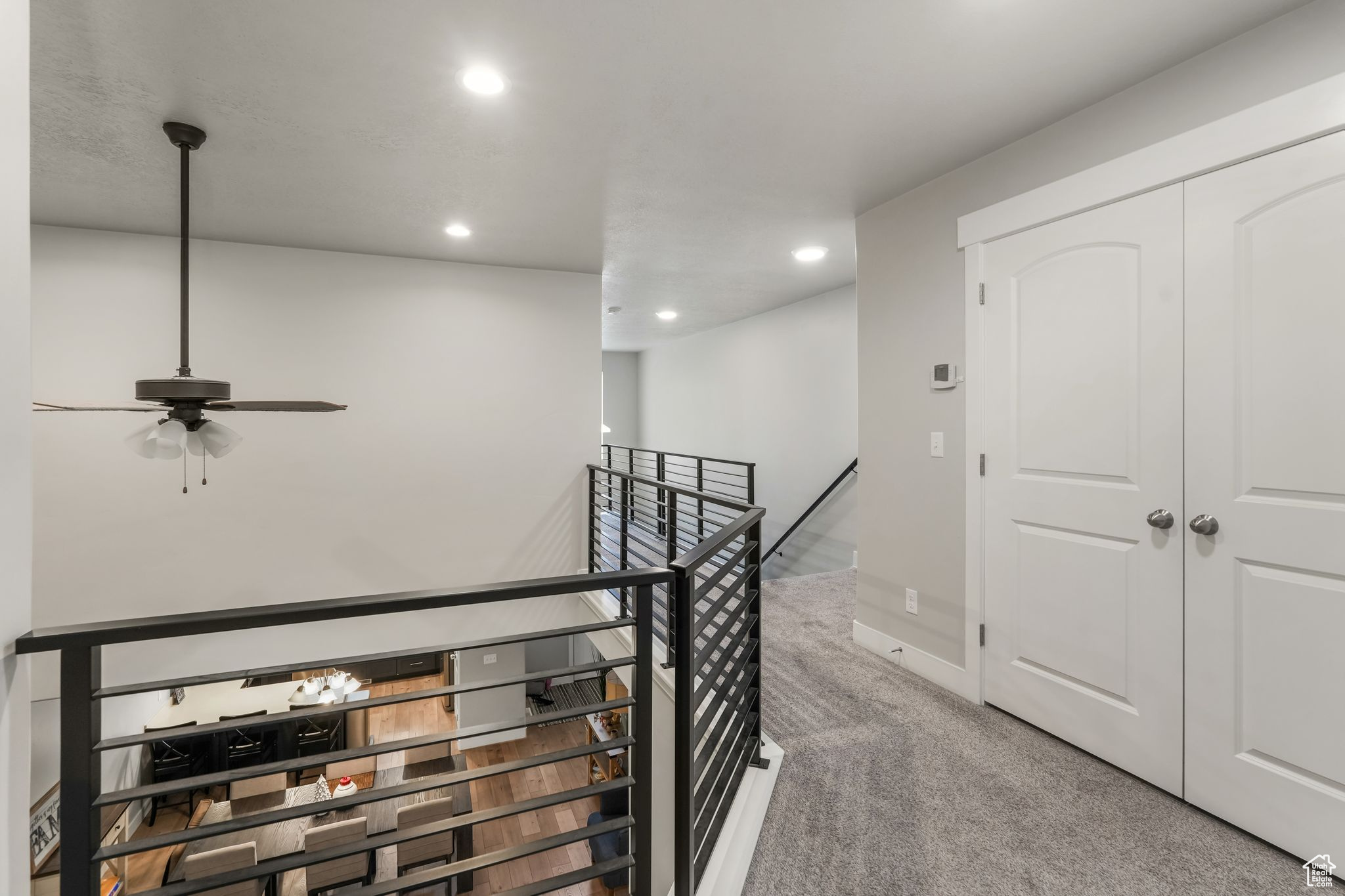 Corridor featuring light colored carpet