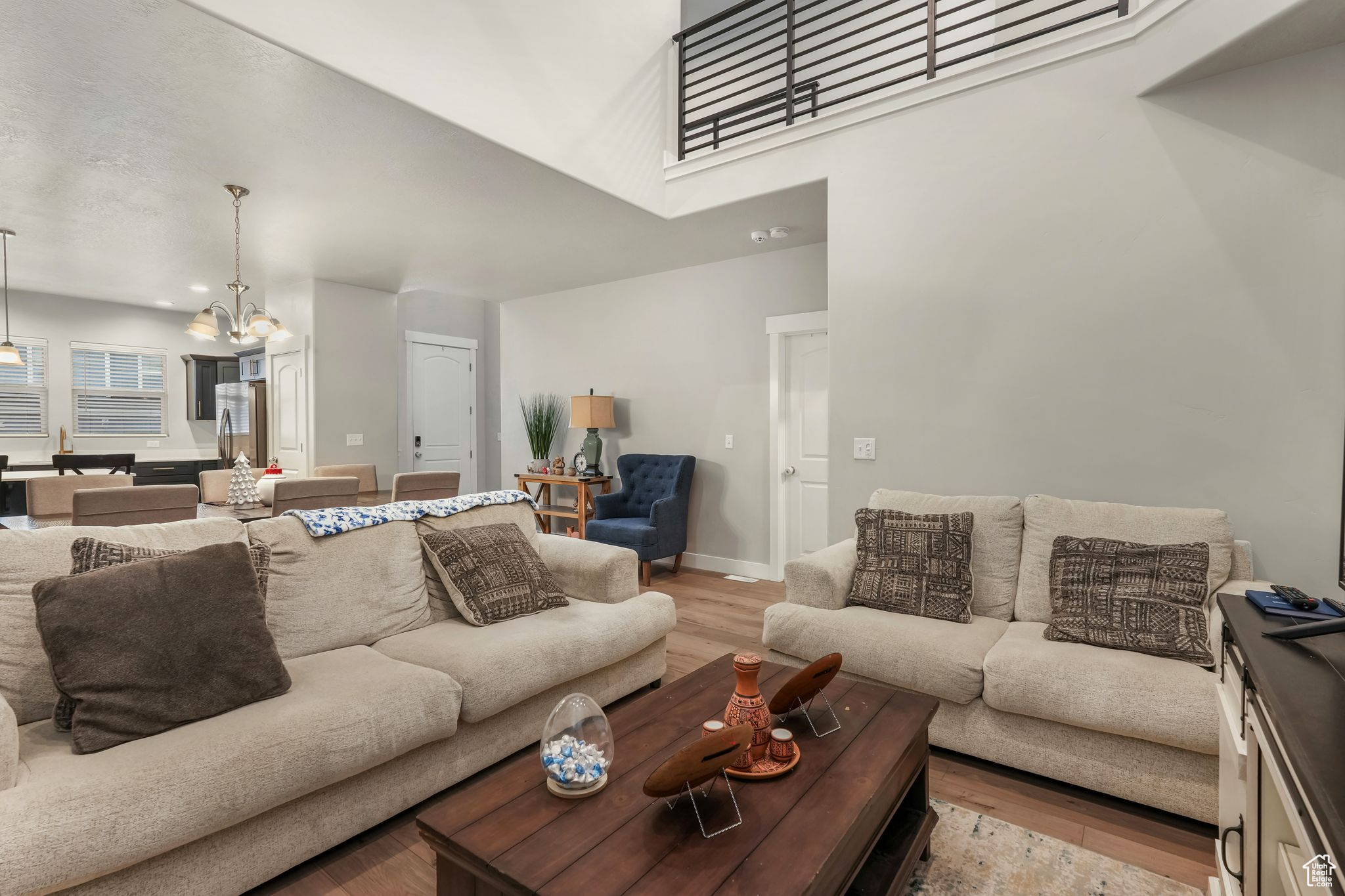 Living room with light hardwood / wood-style floors and a chandelier