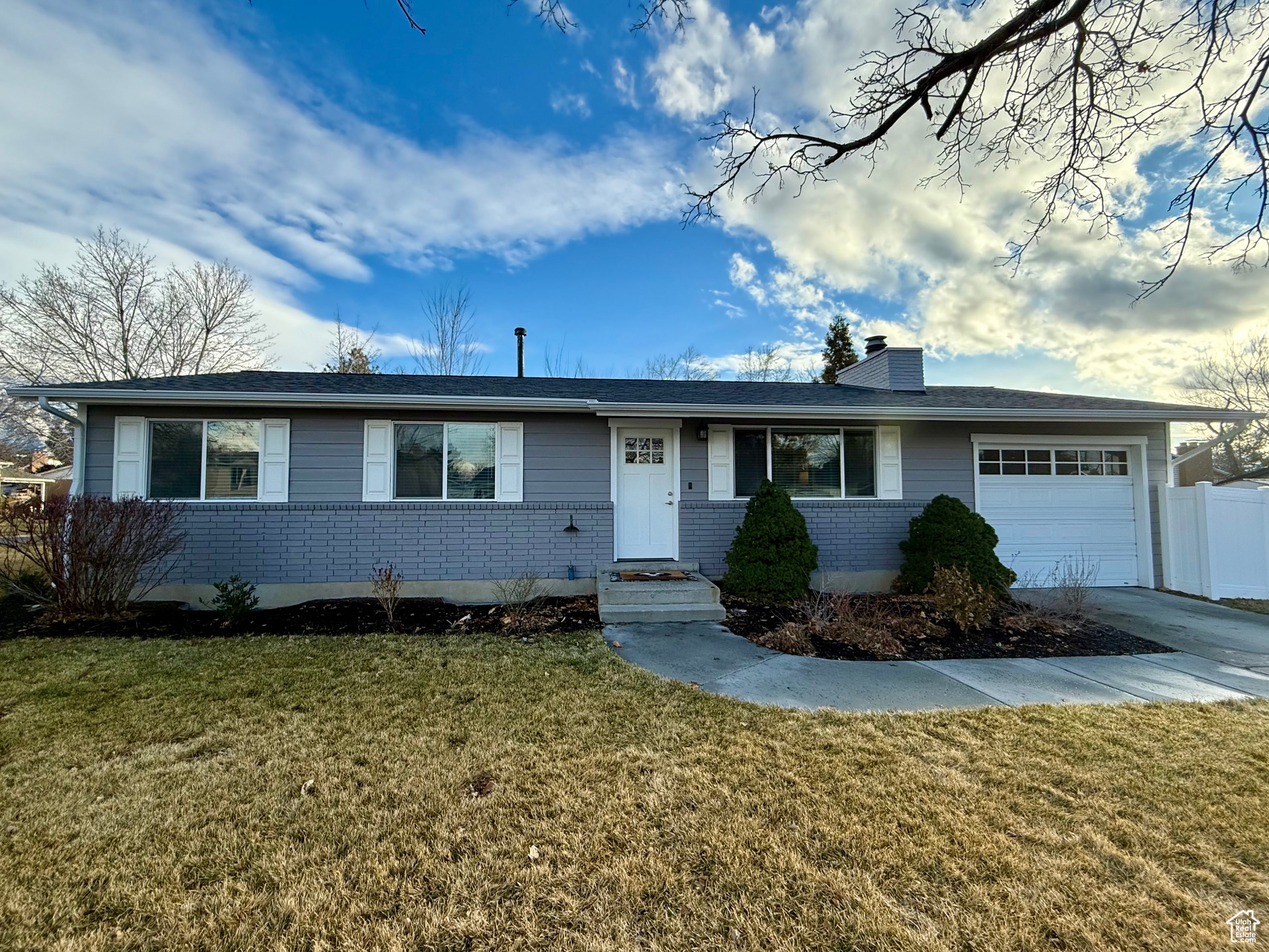 Ranch-style house with a garage and a front lawn