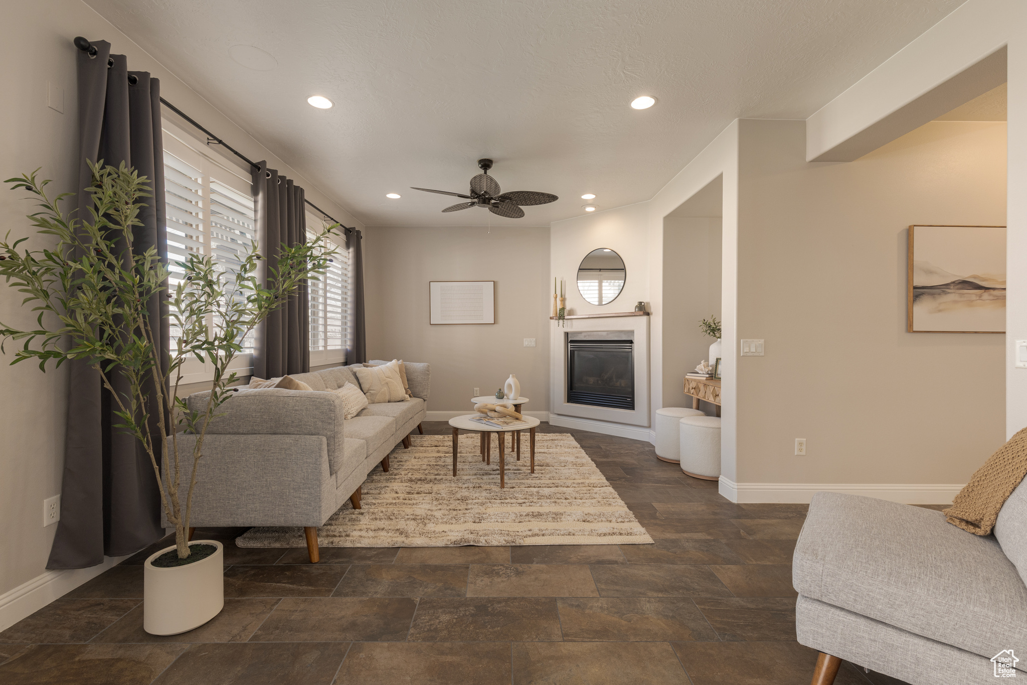 Living area with a glass covered fireplace, recessed lighting, and ceiling fan