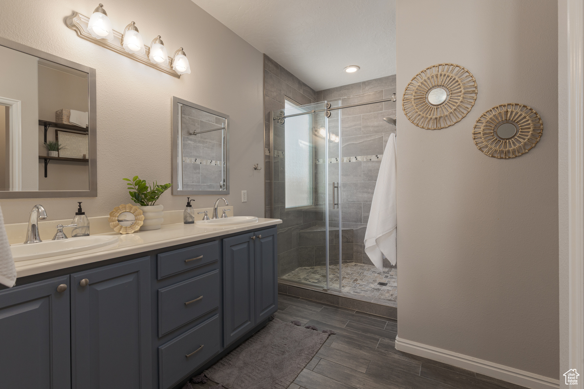 Primary bathroom with double vanity and custom tile walk in shower