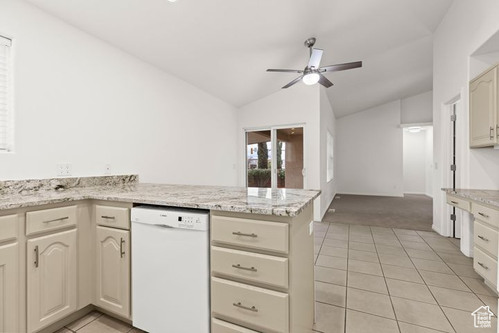 Kitchen with dishwasher, light stone counters, cream cabinets, vaulted ceiling, and kitchen peninsula