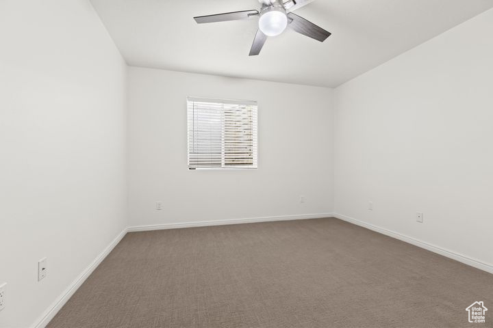 Carpeted empty room with ceiling fan