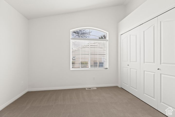 Unfurnished bedroom with a closet and light colored carpet