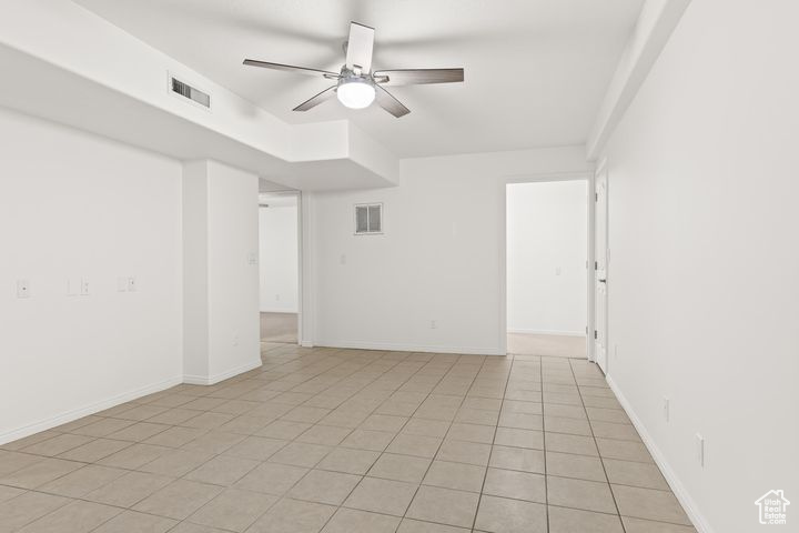 Tiled empty room with ceiling fan