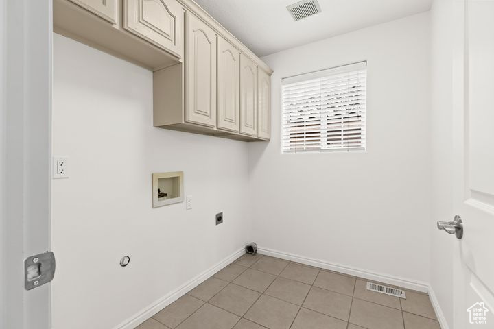 Laundry room featuring cabinets, hookup for a washing machine, electric dryer hookup, and light tile patterned floors