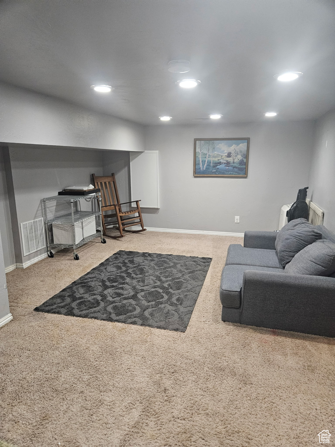 Carpeted living area featuring recessed lighting, visible vents, and baseboards