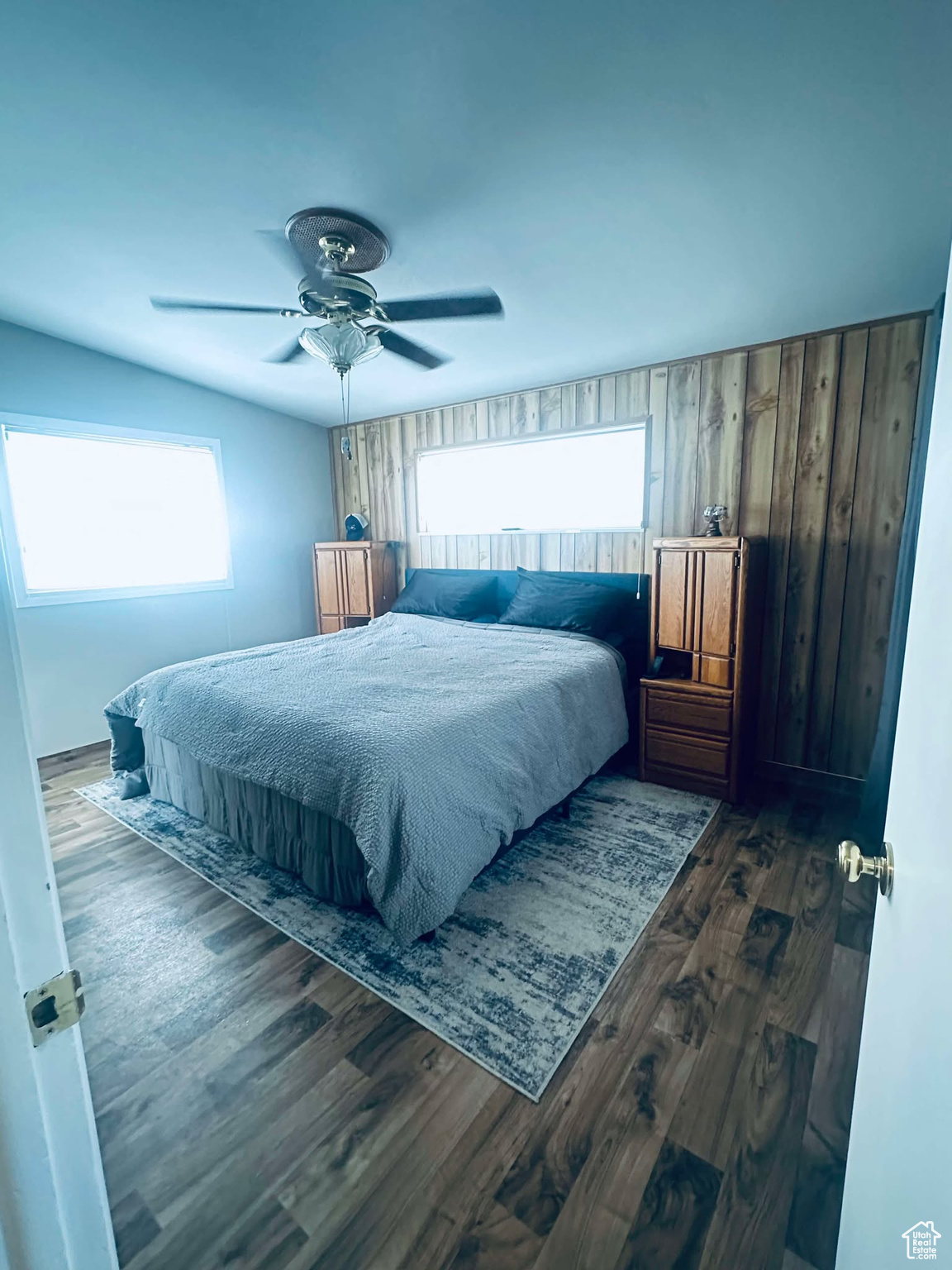 Master Bedroom with ceiling fan, dark hardwood / wood-style floors, and wooden walls