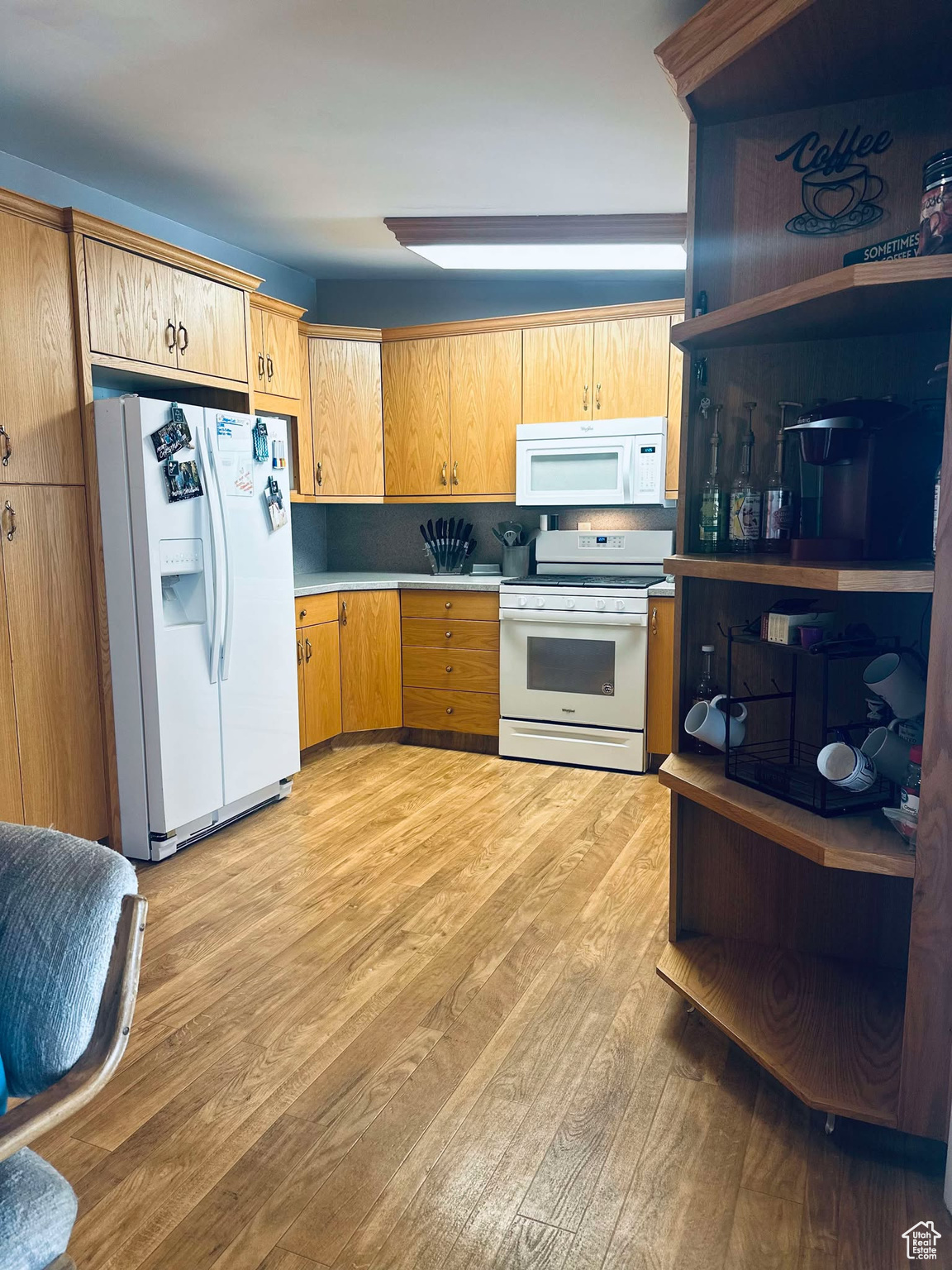 Kitchen featuring light hardwood / wood-style flooring and white appliances