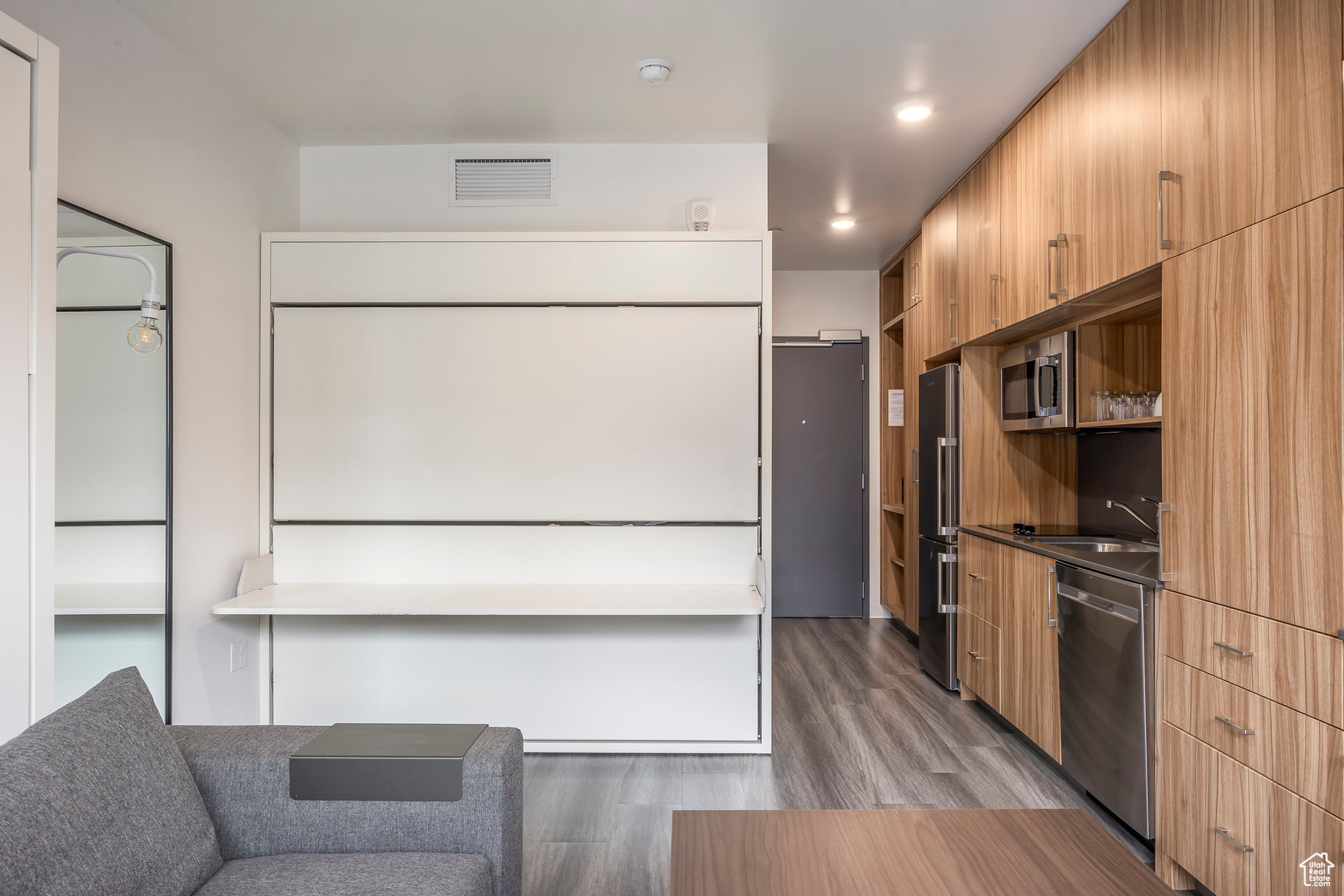 Kitchen with sink, wood-type flooring, and appliances with stainless steel finishes