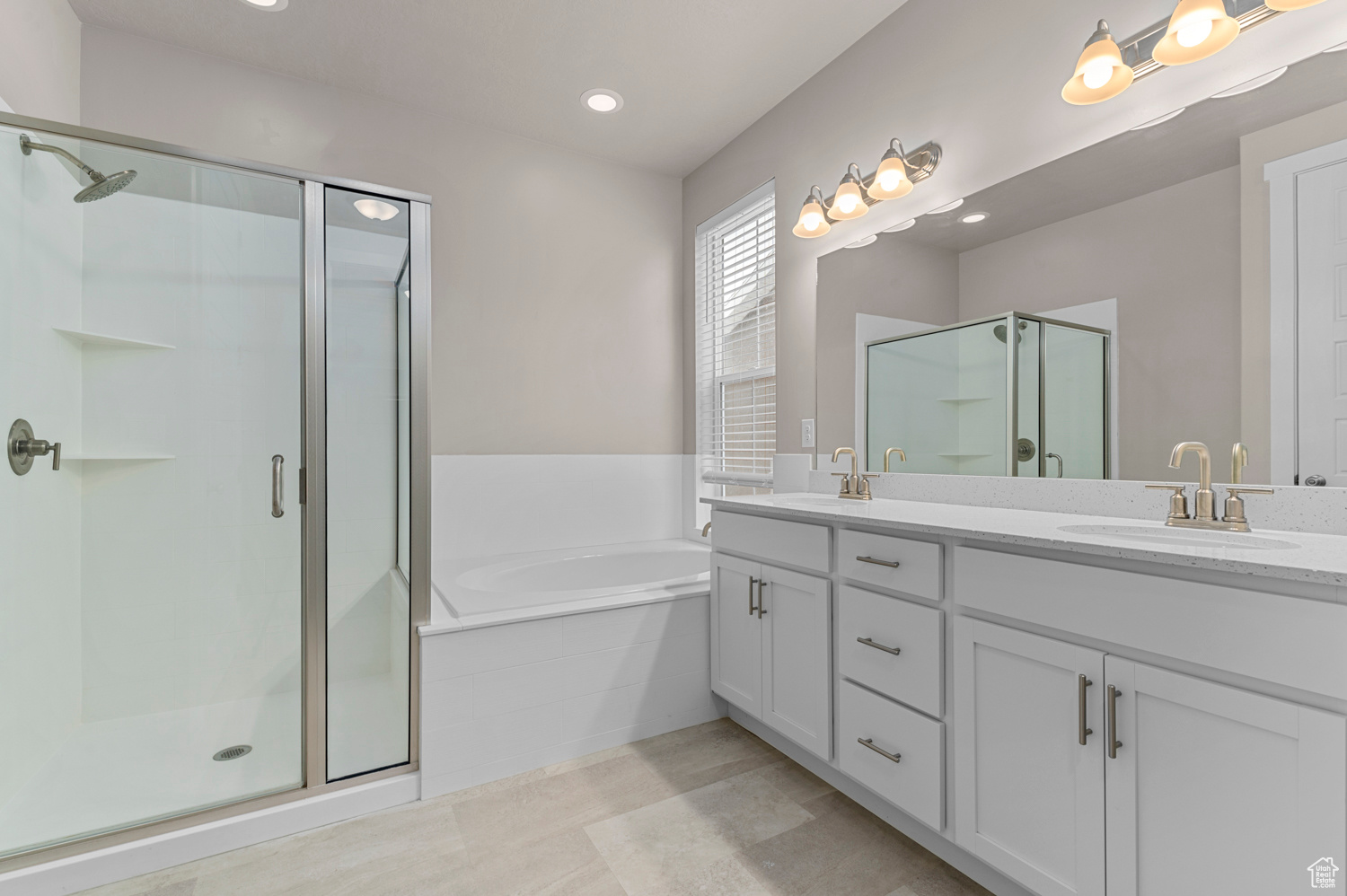 Bathroom featuring separate shower and tub and vanity