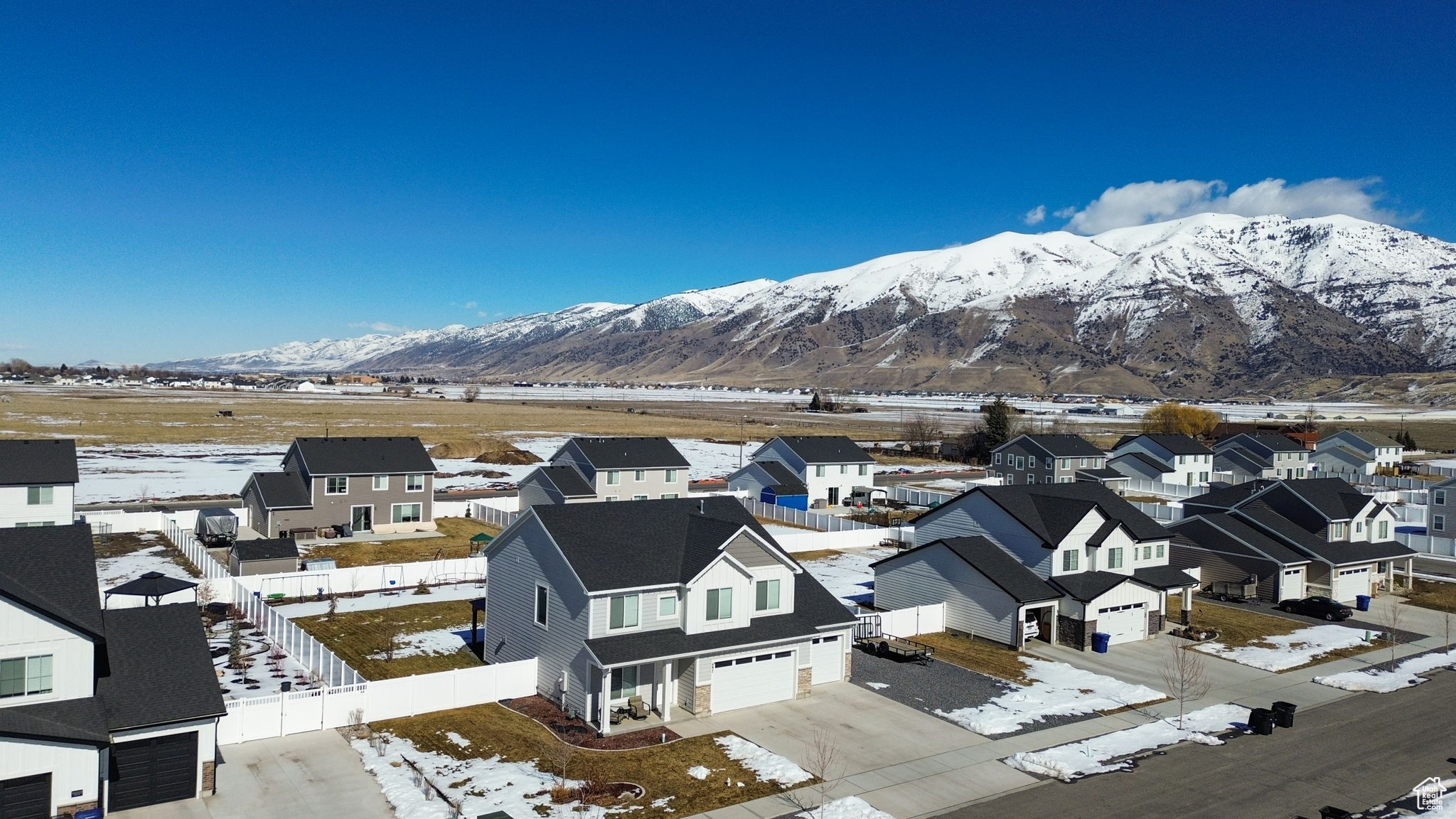 Snowy aerial view featuring a residential view and a mountain view