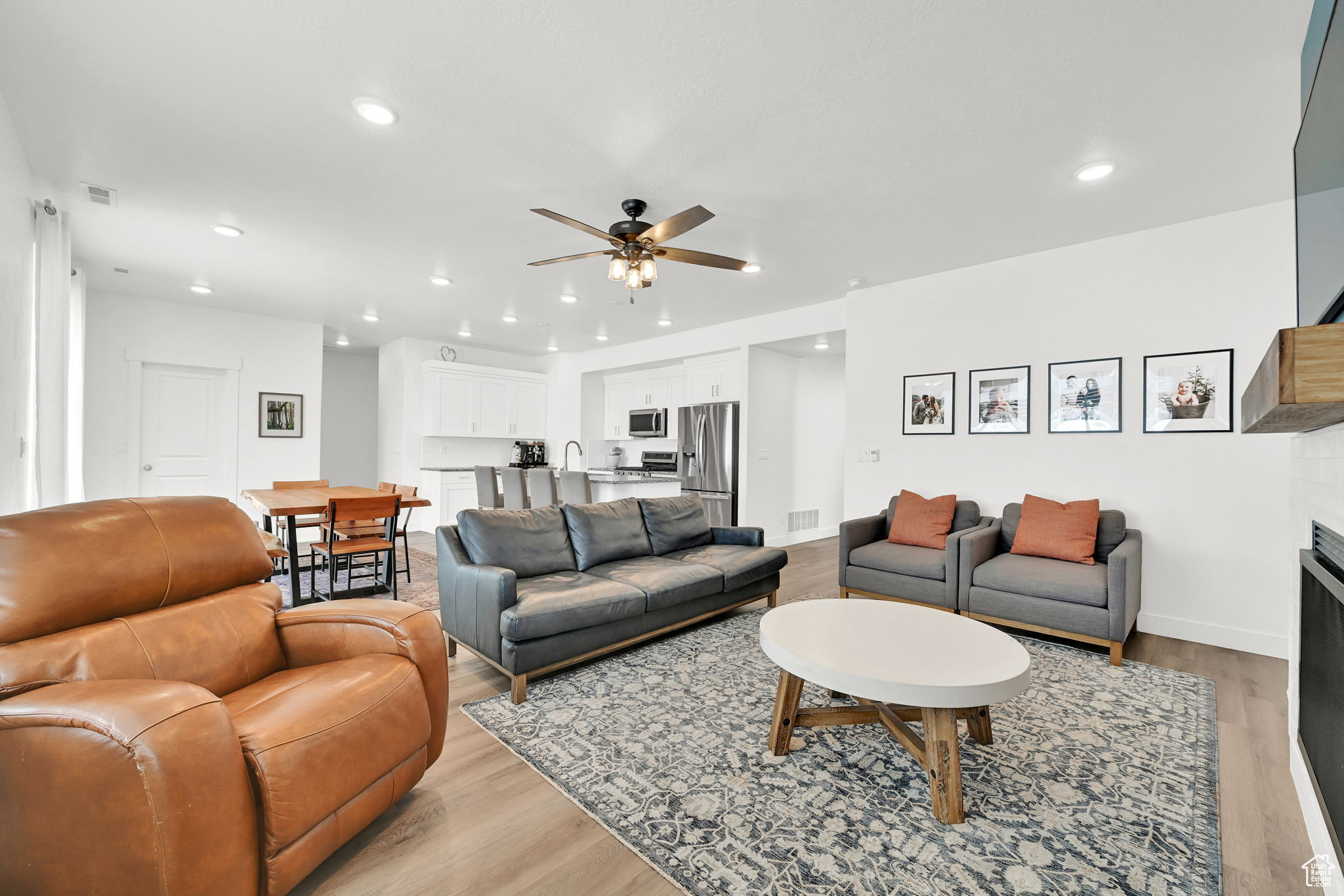 Living room with ceiling fan, sink, and light hardwood / wood-style floors