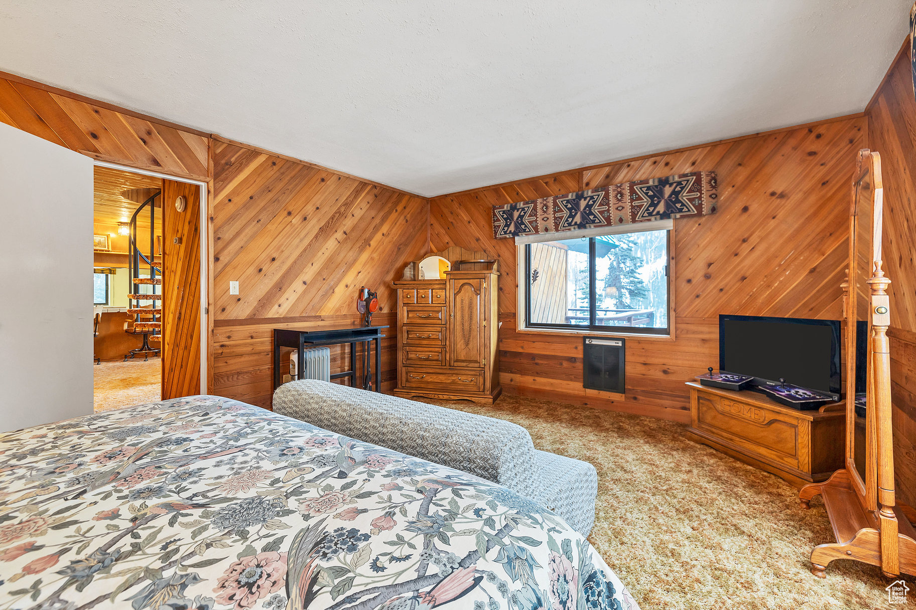 Carpeted bedroom featuring wood walls