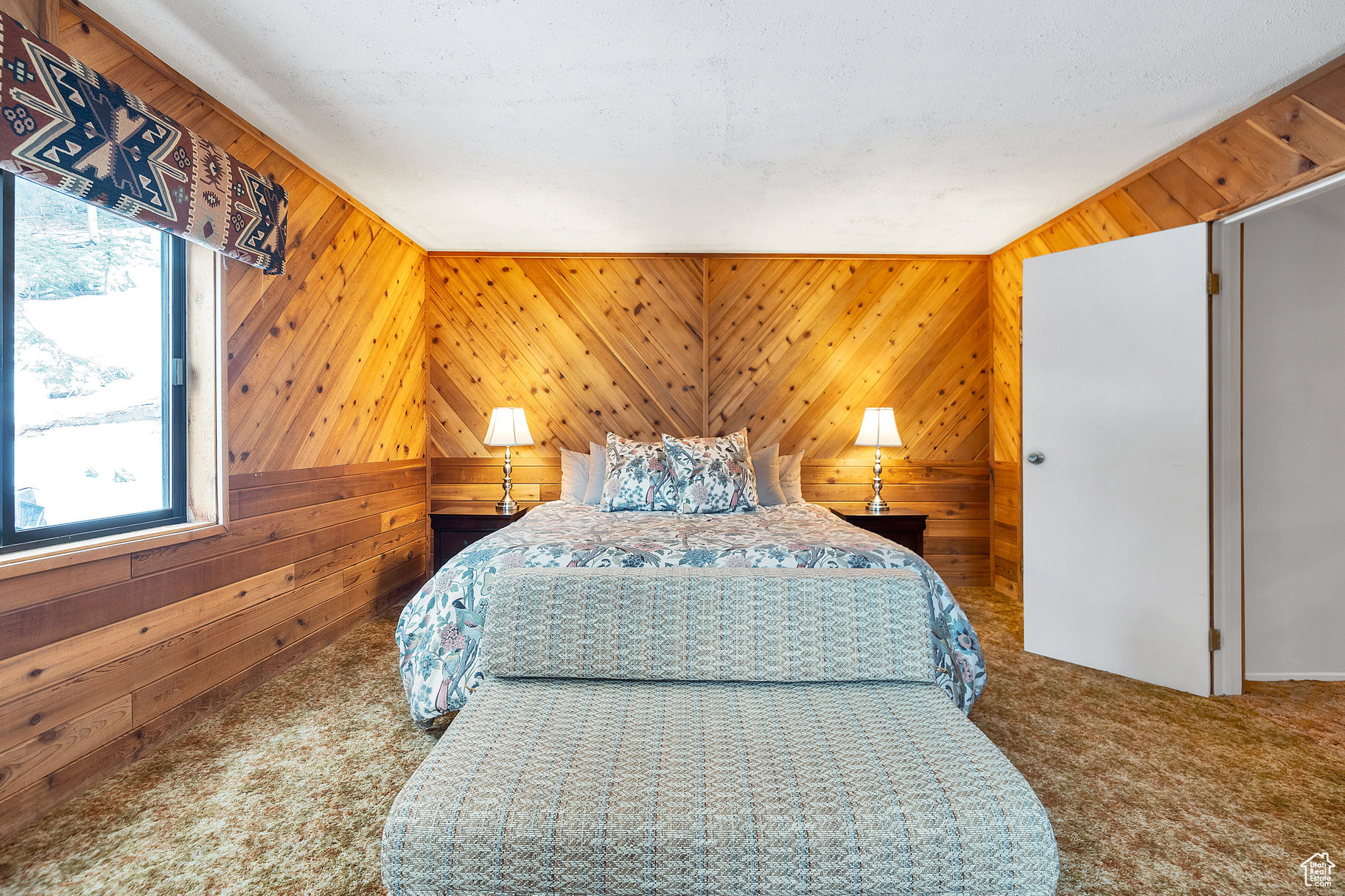 Bedroom with wooden walls and carpet flooring