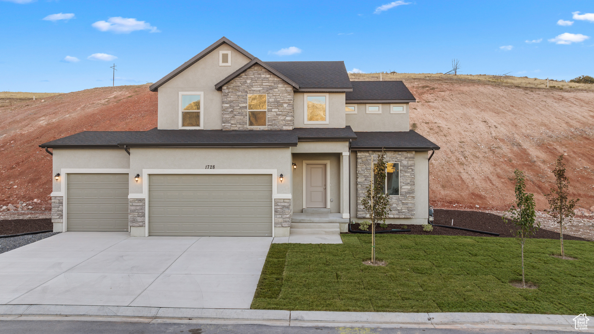 View of front facade featuring a front lawn and a garage