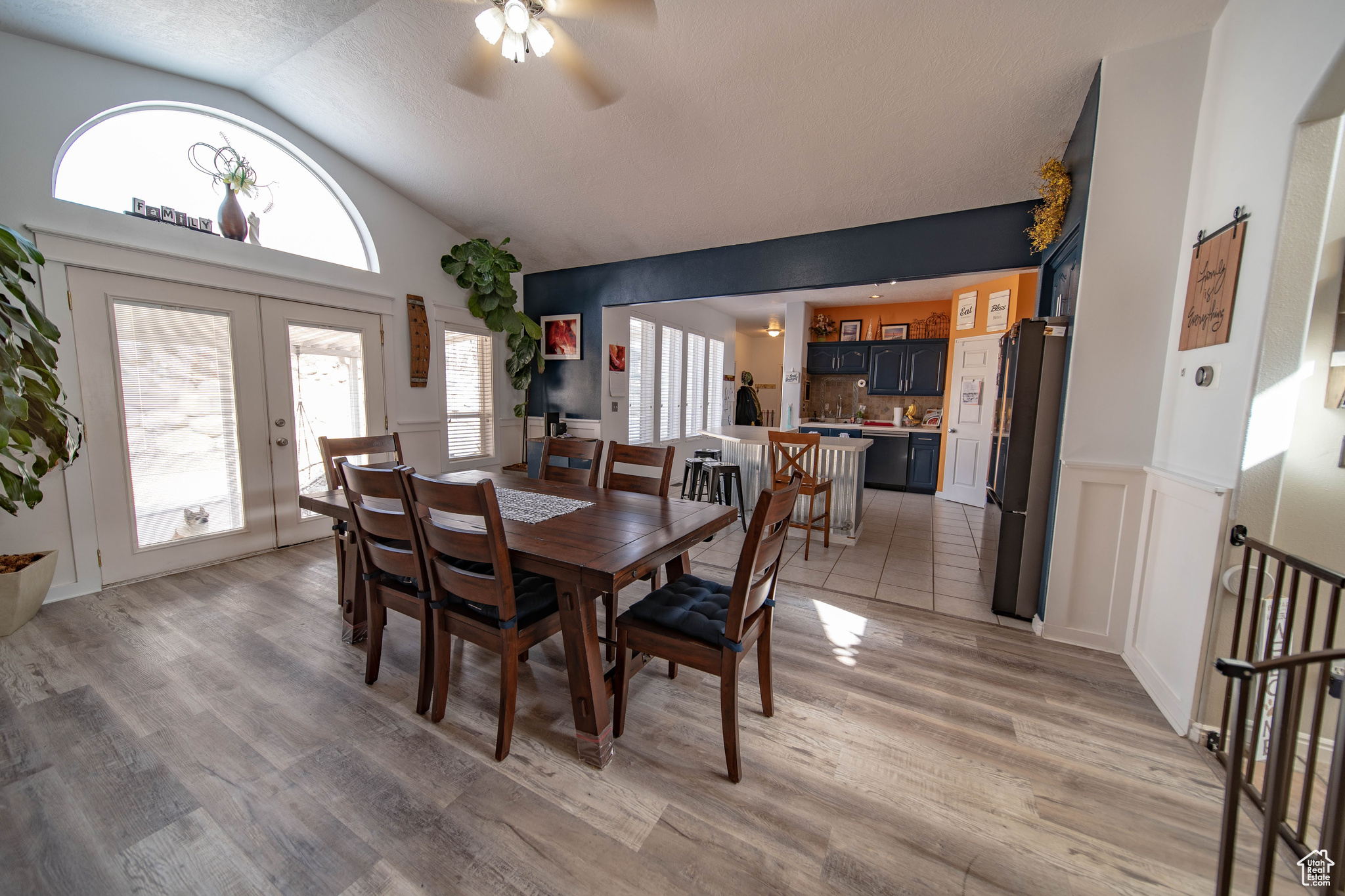 Dining area featuring light wood-type flooring, french doors, lofted ceiling, and ceiling fan