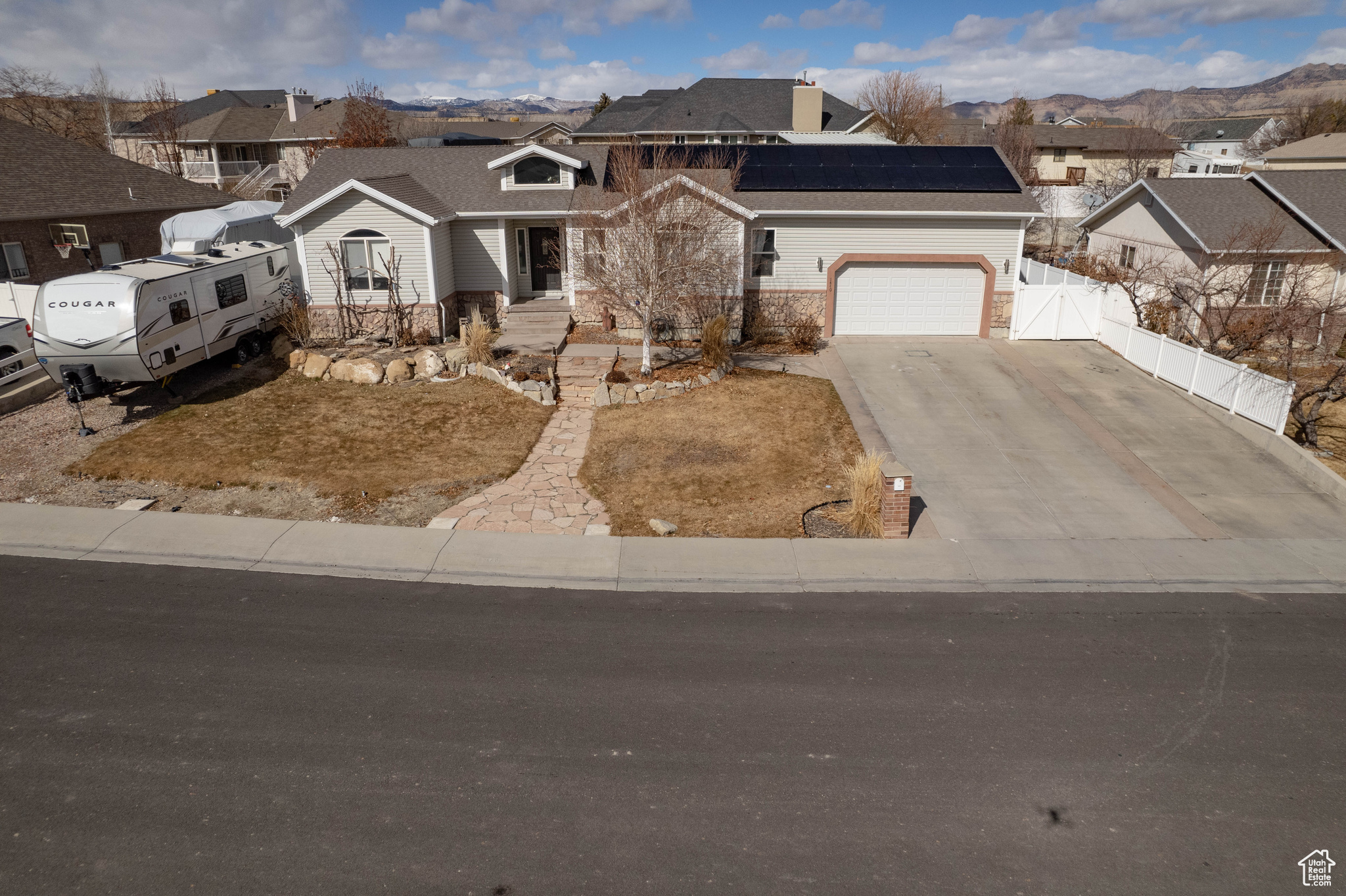 View of front of home featuring a mountain view and solar panels