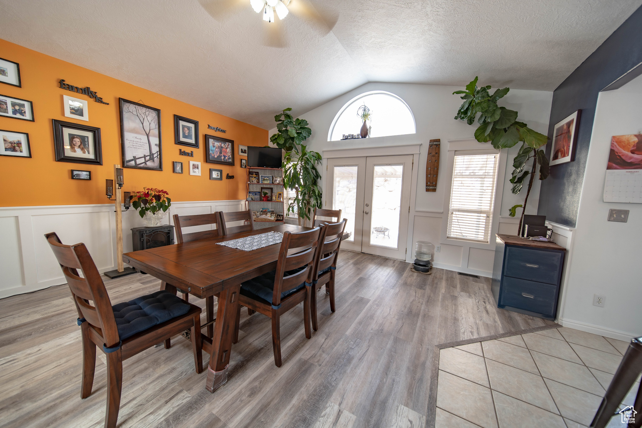 Dining space with light wood-type flooring, vaulted ceiling, french doors, and a textured ceiling