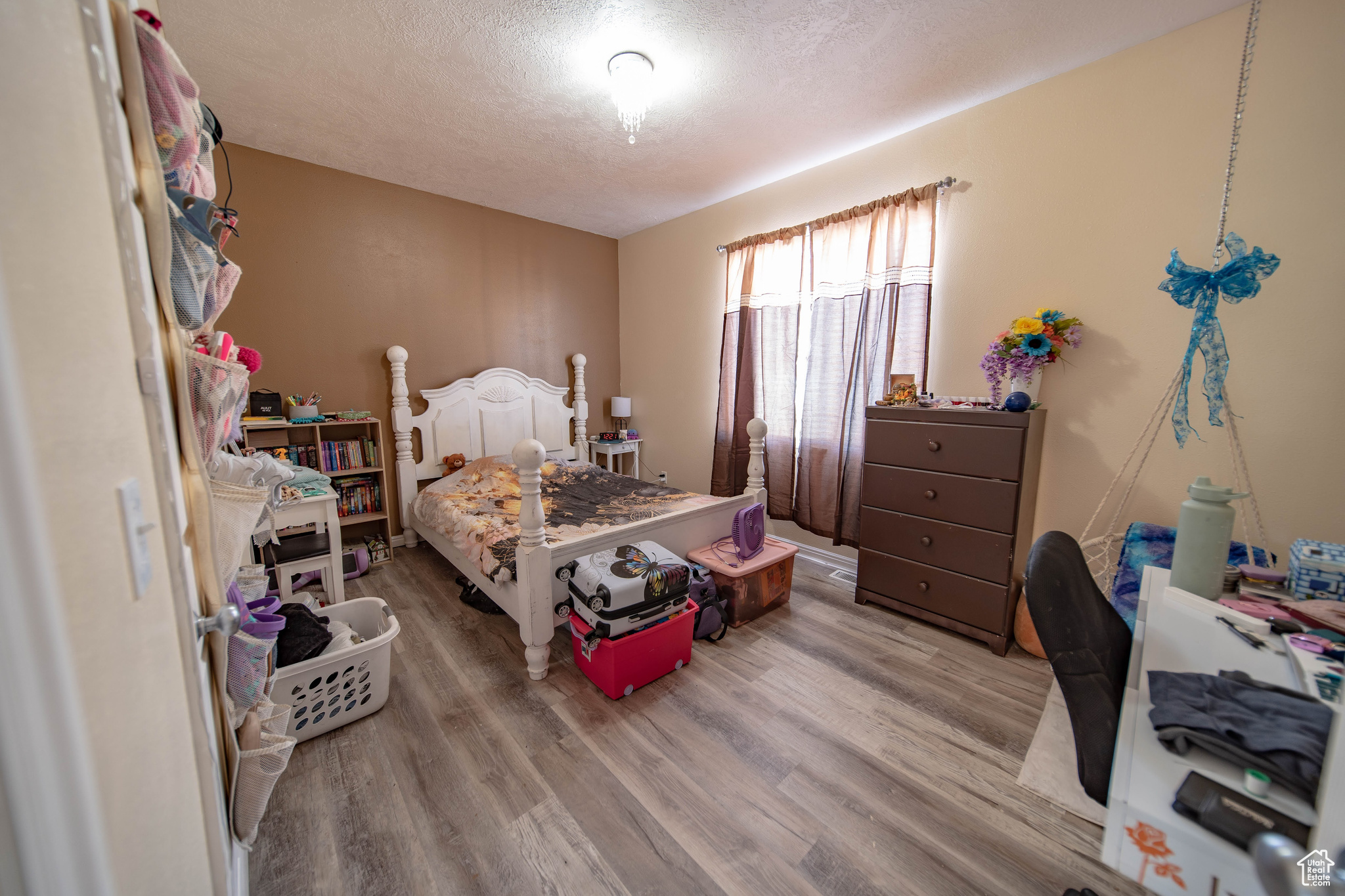 Bedroom with light wood-type flooring and a textured ceiling