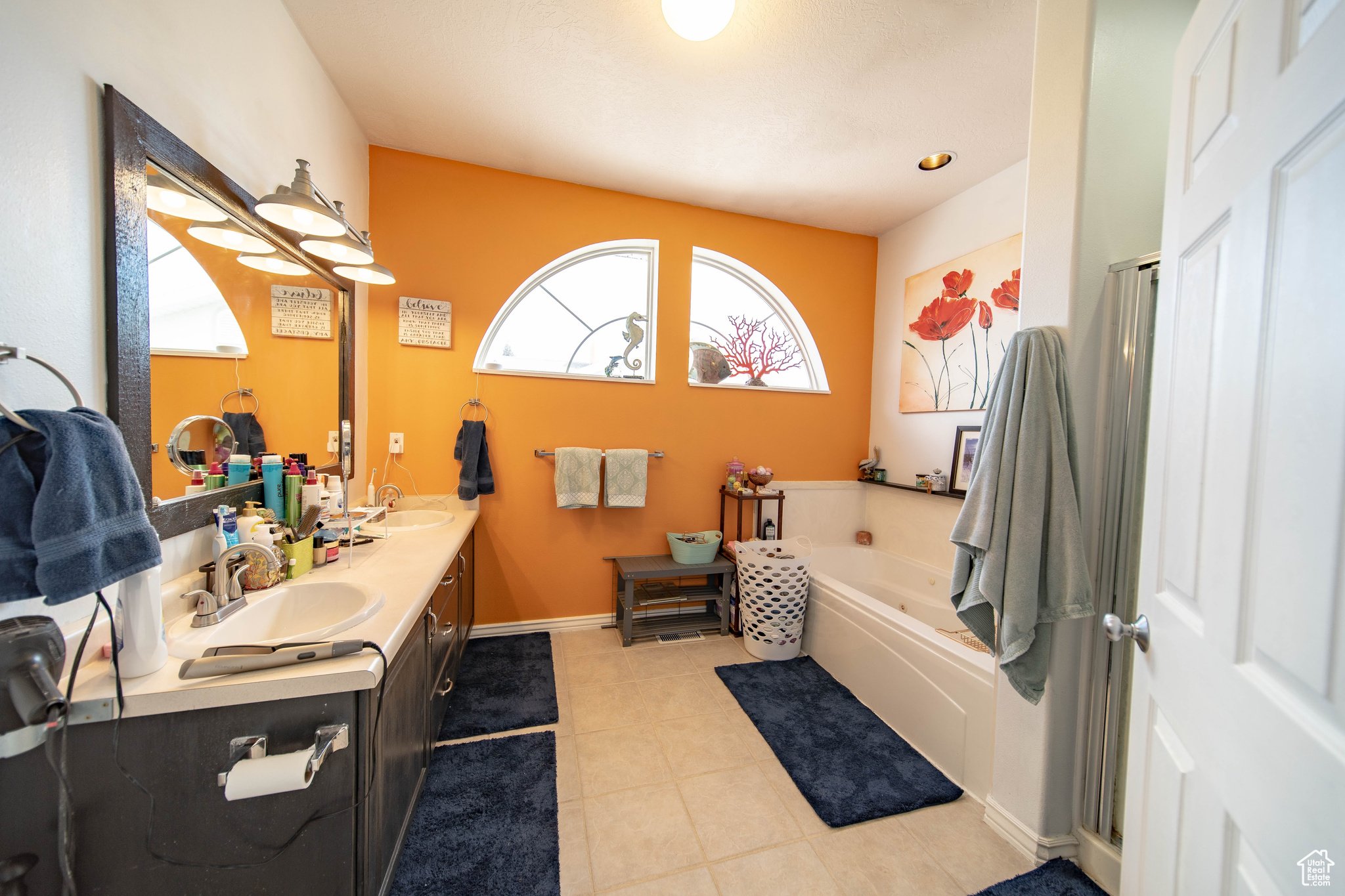 Bathroom featuring tile patterned flooring, a tub to relax in, and vanity