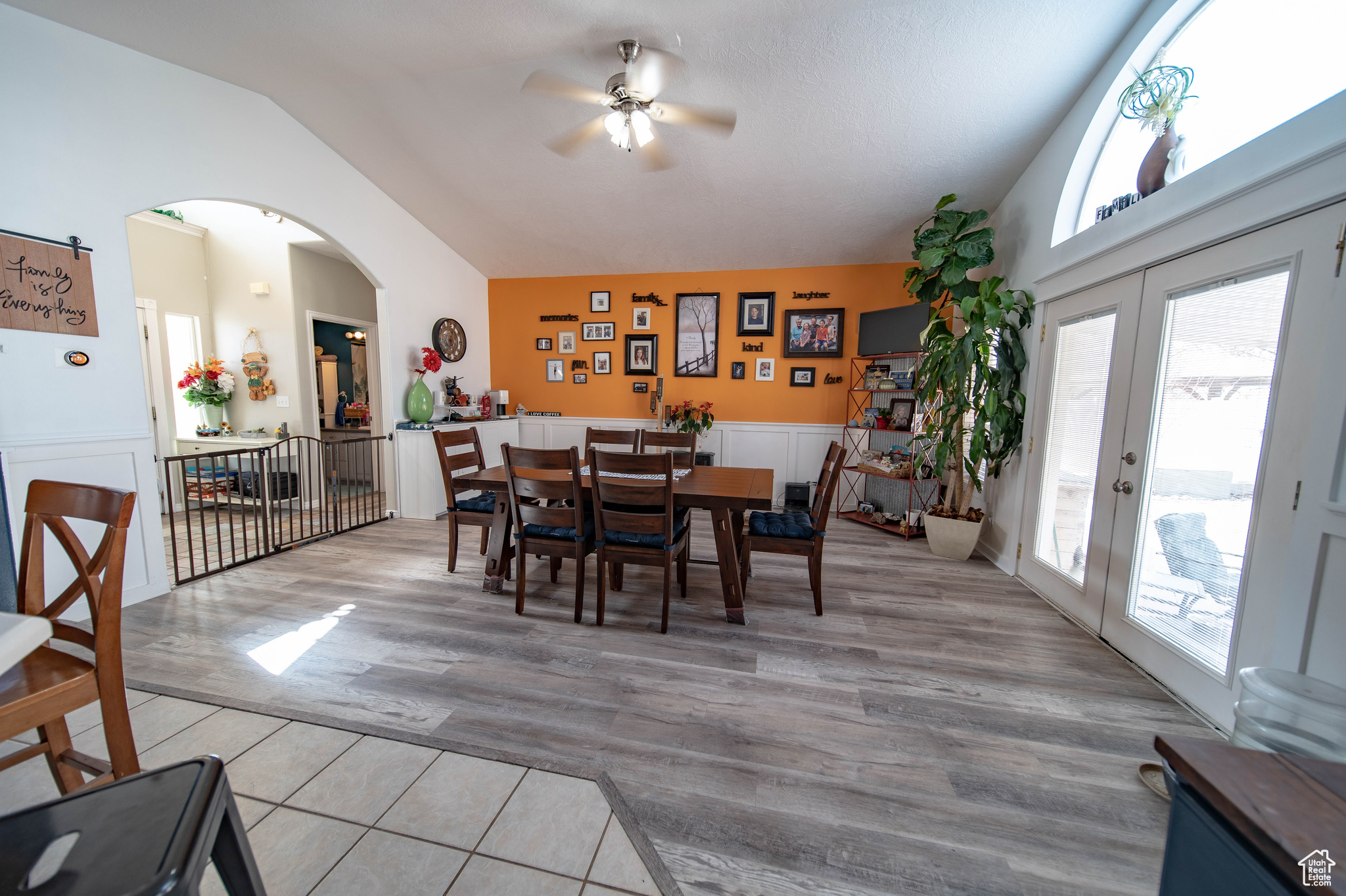 Dining area featuring high vaulted ceiling, light wood-type flooring, french doors, and ceiling fan