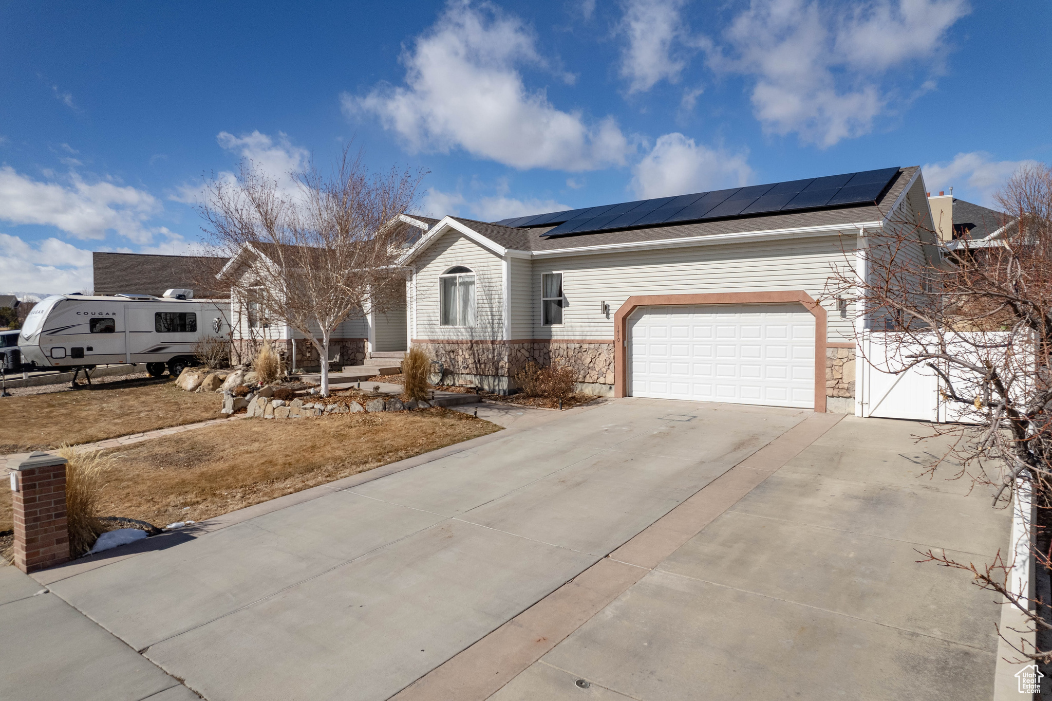 Ranch-style house with solar panels and a garage
