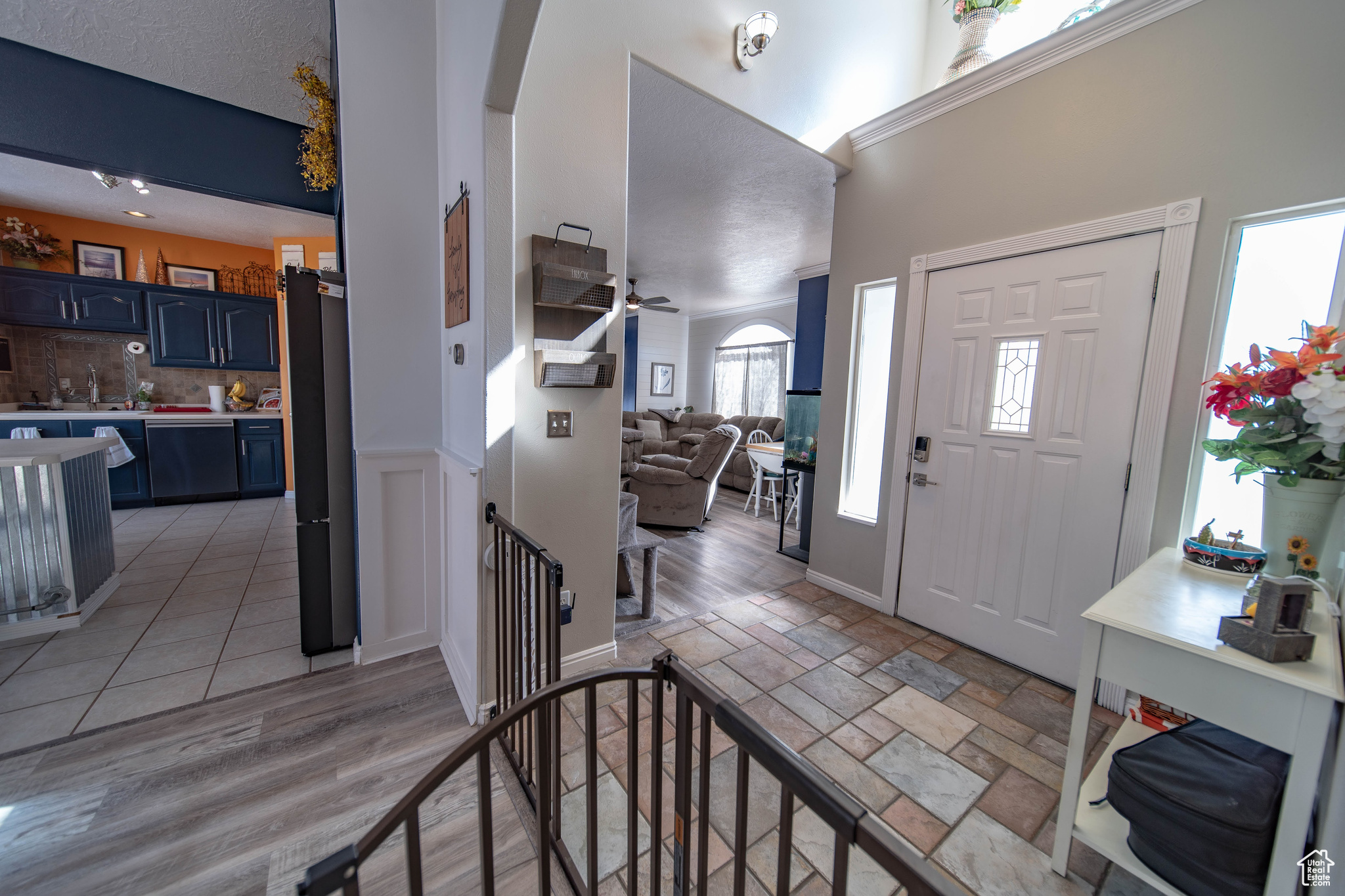 Foyer featuring ceiling fan, sink, a towering ceiling, and light hardwood / wood-style floors