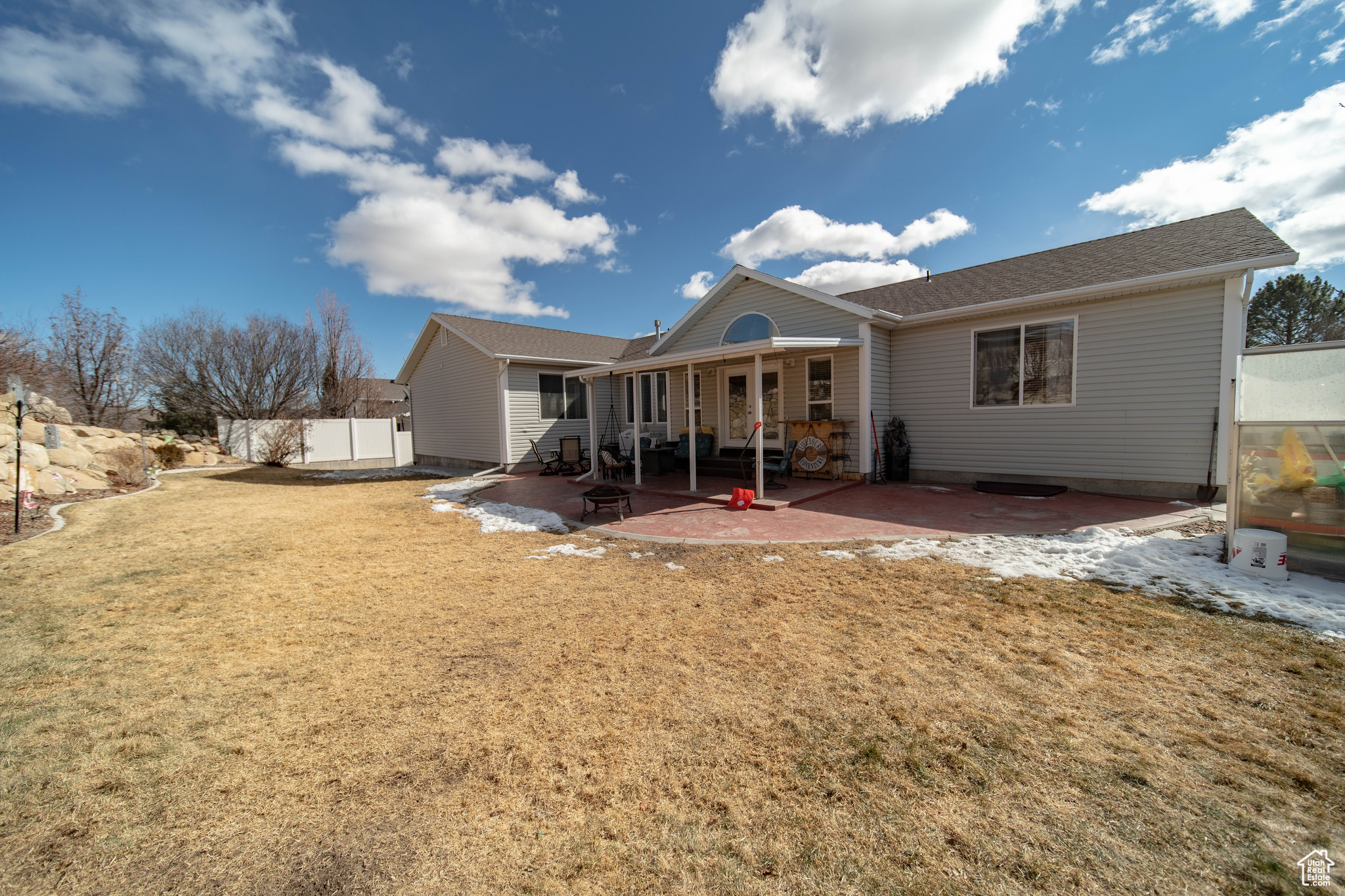 Back of house with a patio and a lawn