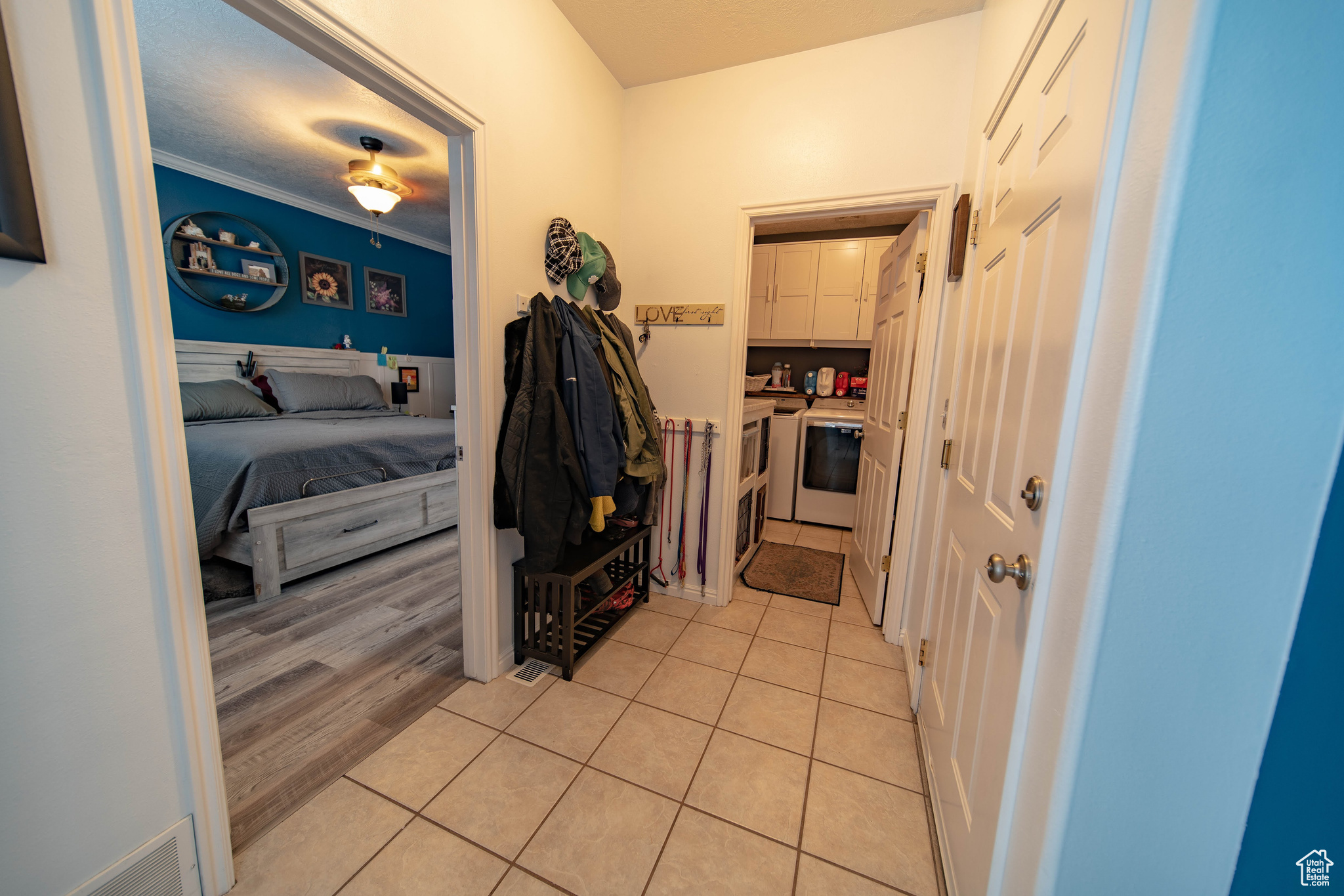 Hallway with light tile patterned floors and crown molding