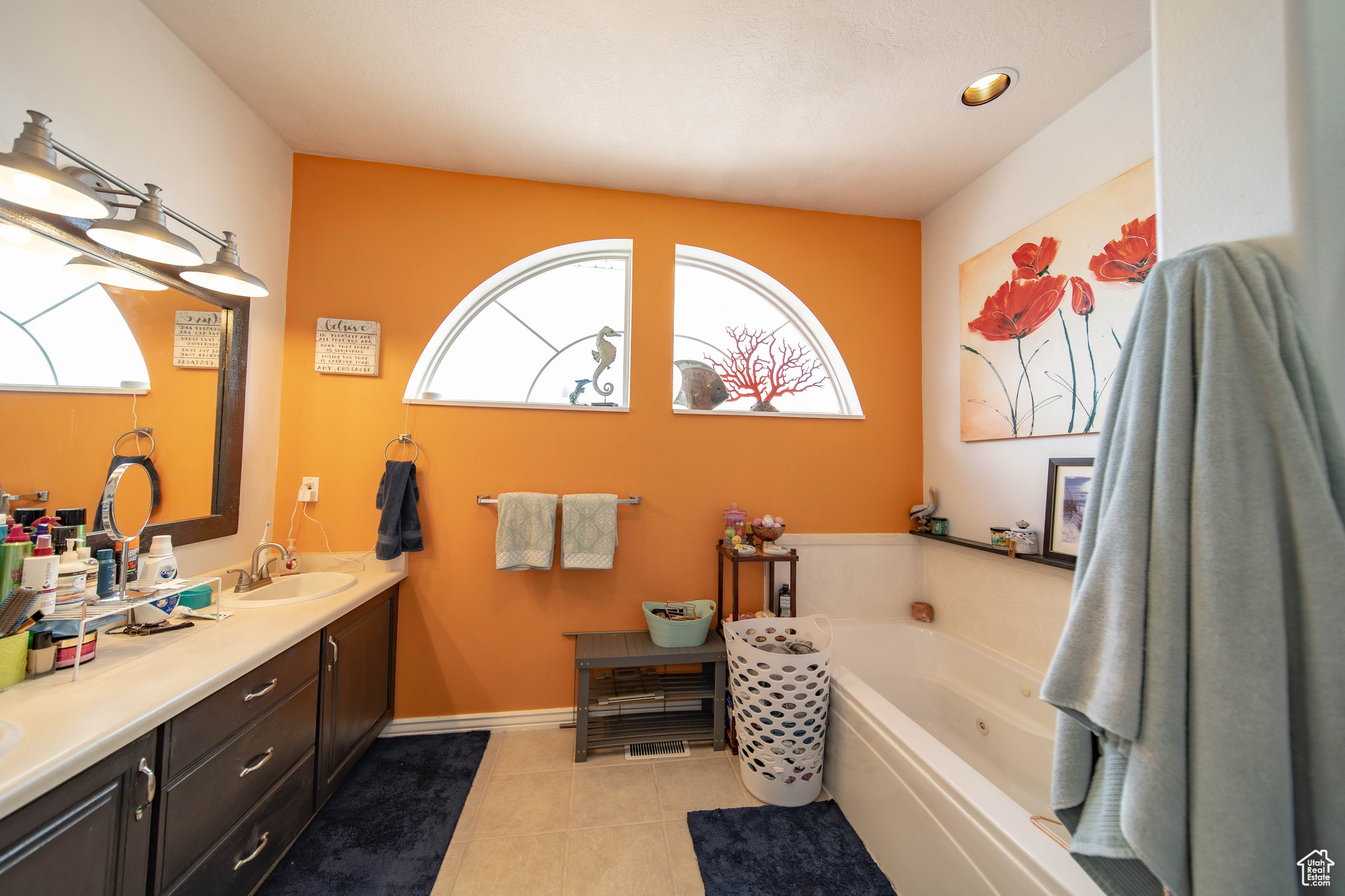 Bathroom with a washtub, tile patterned flooring, and vanity
