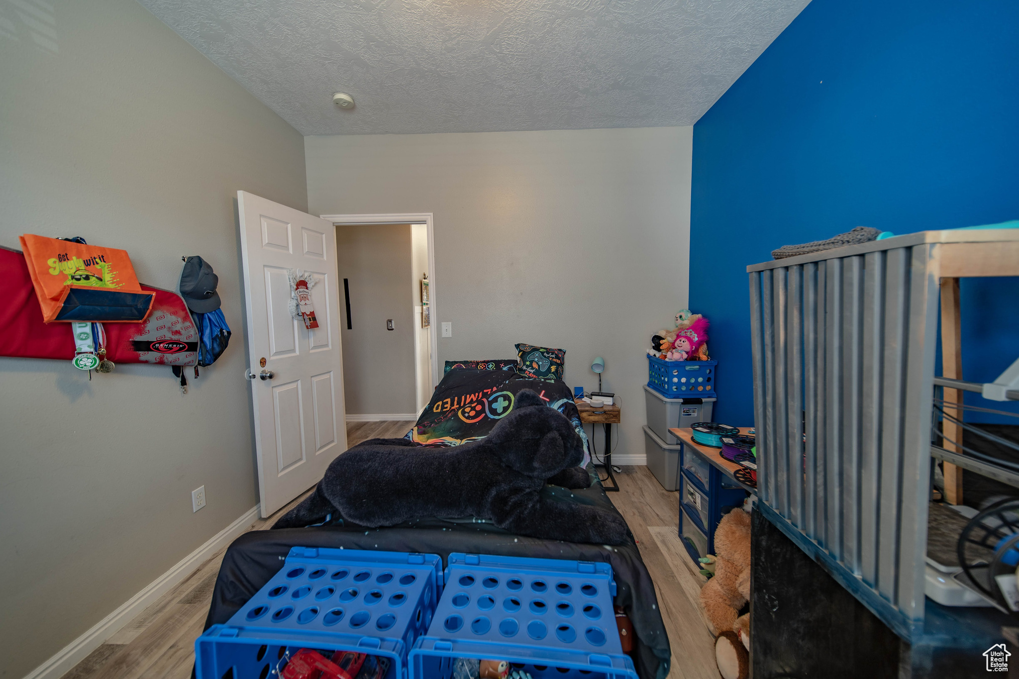 Bedroom with light hardwood / wood-style floors and a textured ceiling