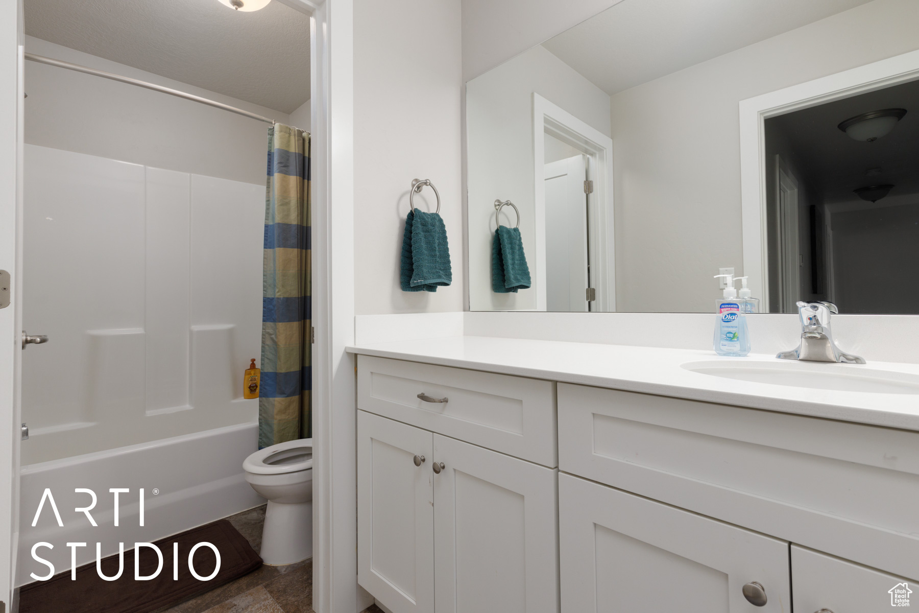Full bathroom with shower / bath combination with curtain, vanity, and toilet
