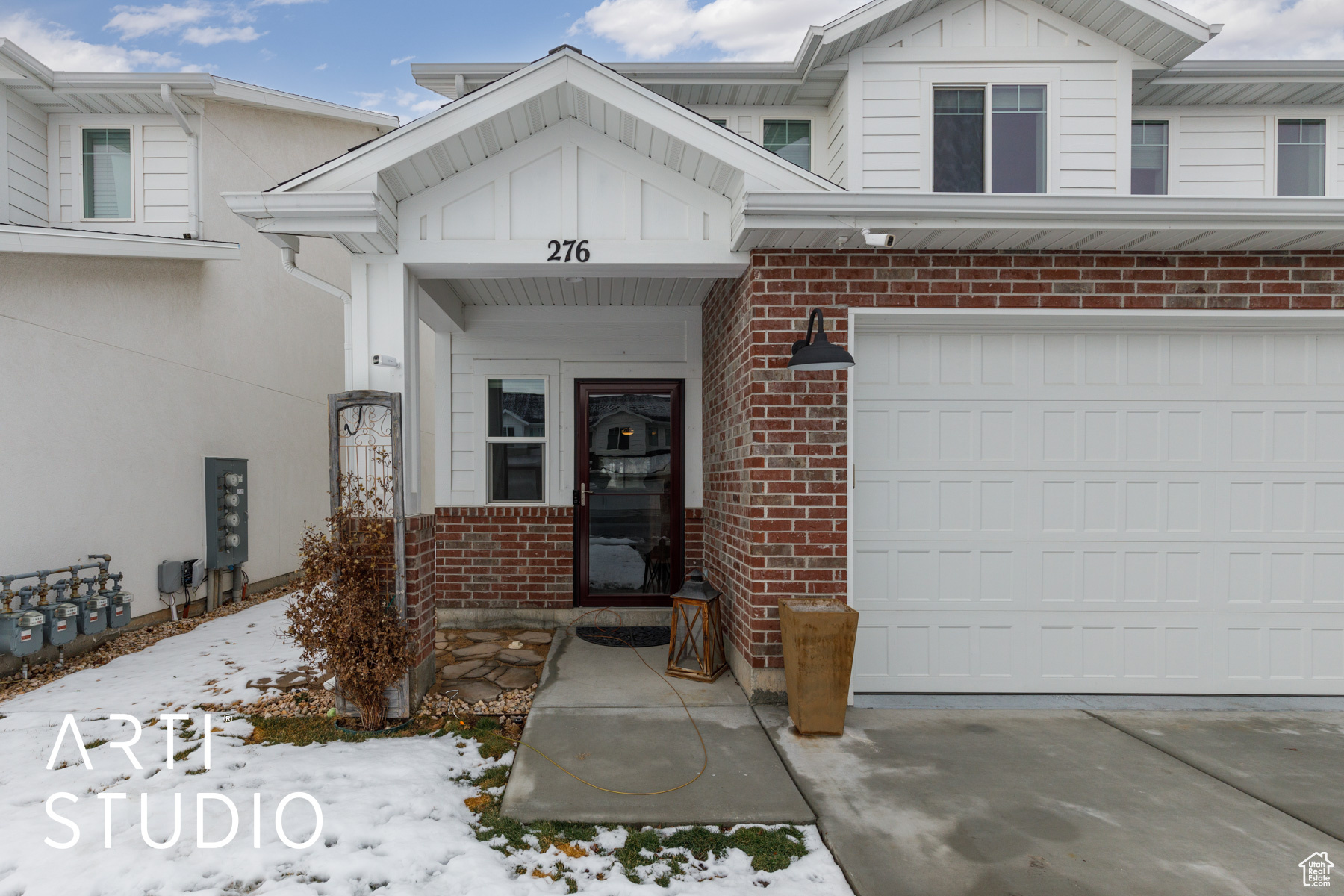 Snow covered property entrance with a 2-car garage