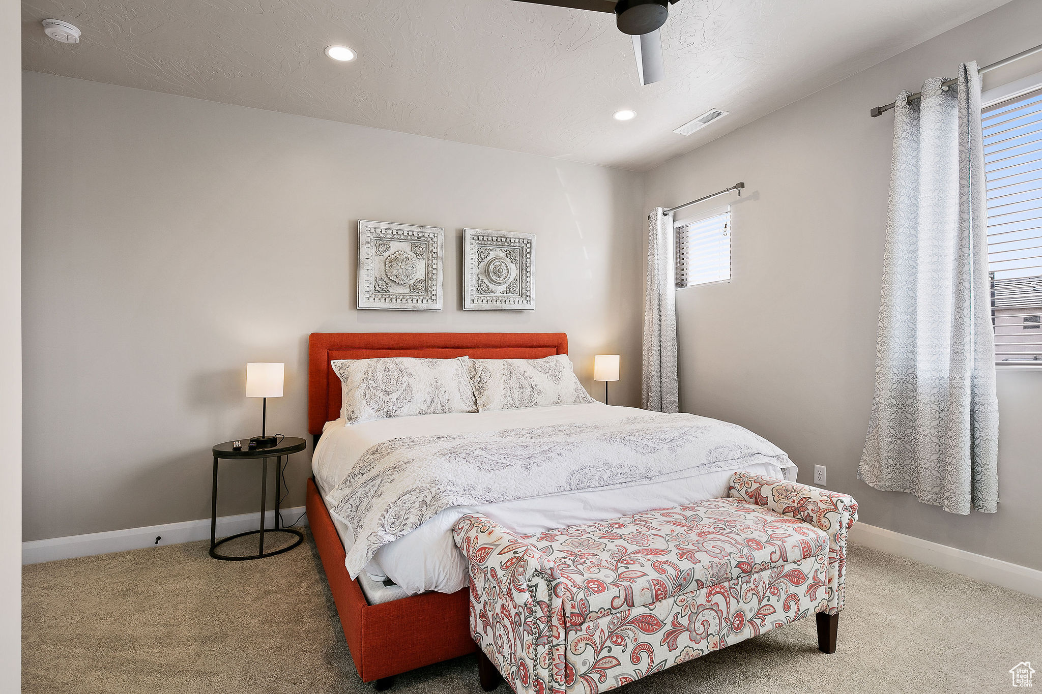 Carpeted bedroom featuring ceiling fan and a textured ceiling