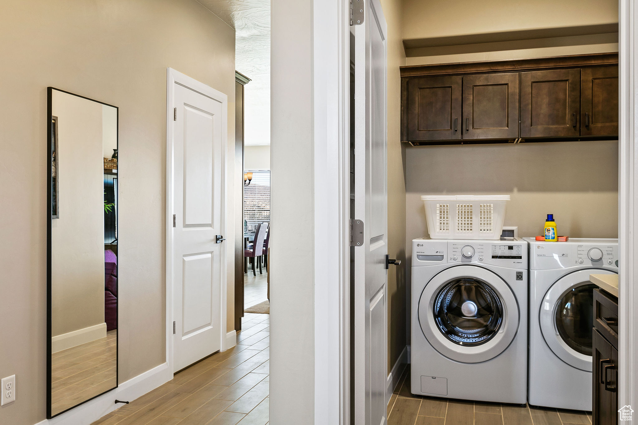 Laundry area with light wood-type flooring, separate washer and dryer, and cabinets