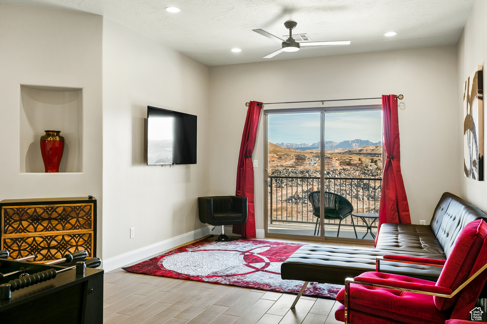 Living room featuring ceiling fan, a textured ceiling, and light hardwood / wood-style floors