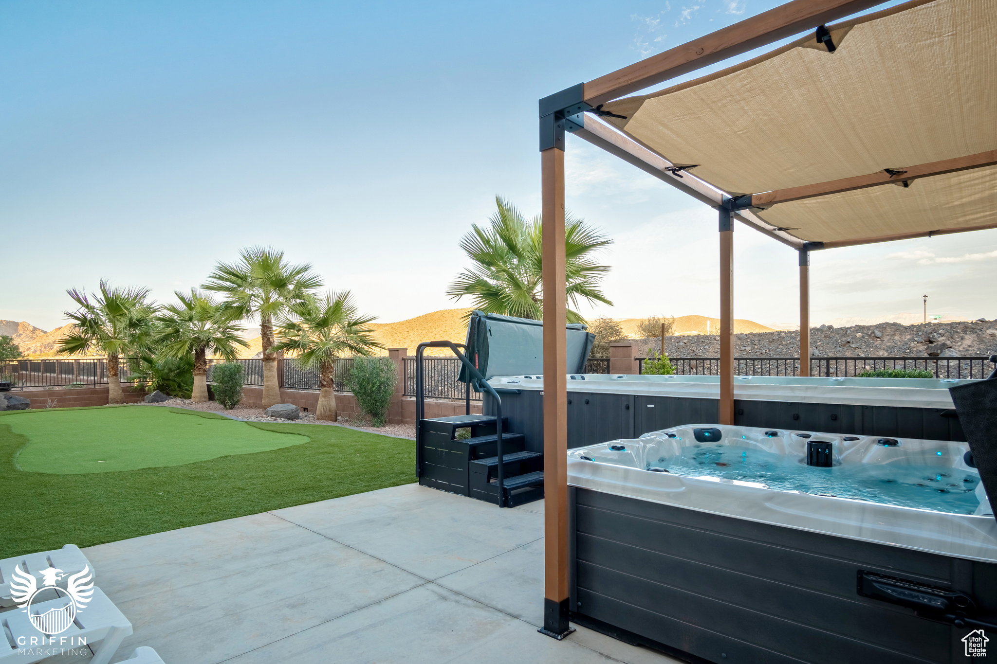 Patio terrace at dusk with a mountain view and a hot tub