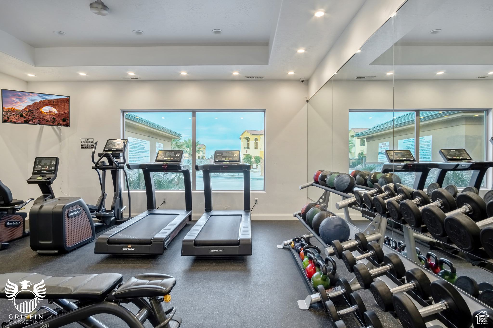 Gym featuring a raised ceiling and a healthy amount of sunlight