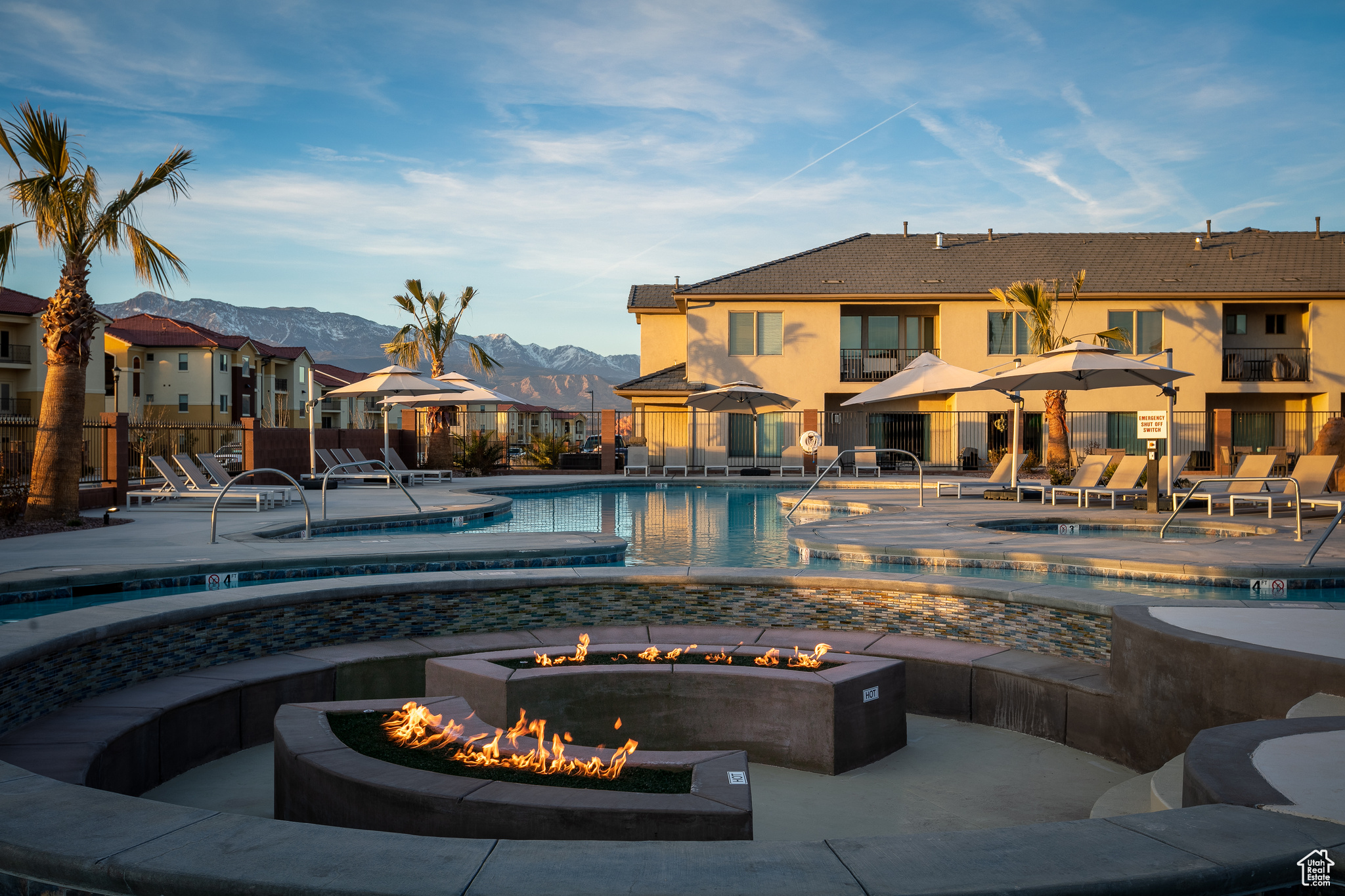 View of swimming pool with a patio, a fire pit, a mountain view, and a hot tub