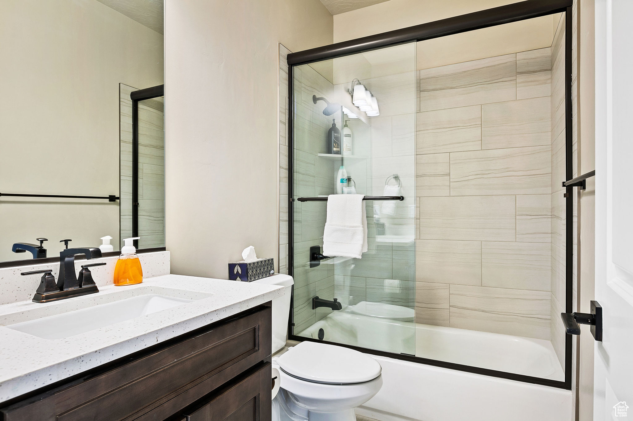 Full bathroom with vanity, toilet, and enclosed tub / shower combo